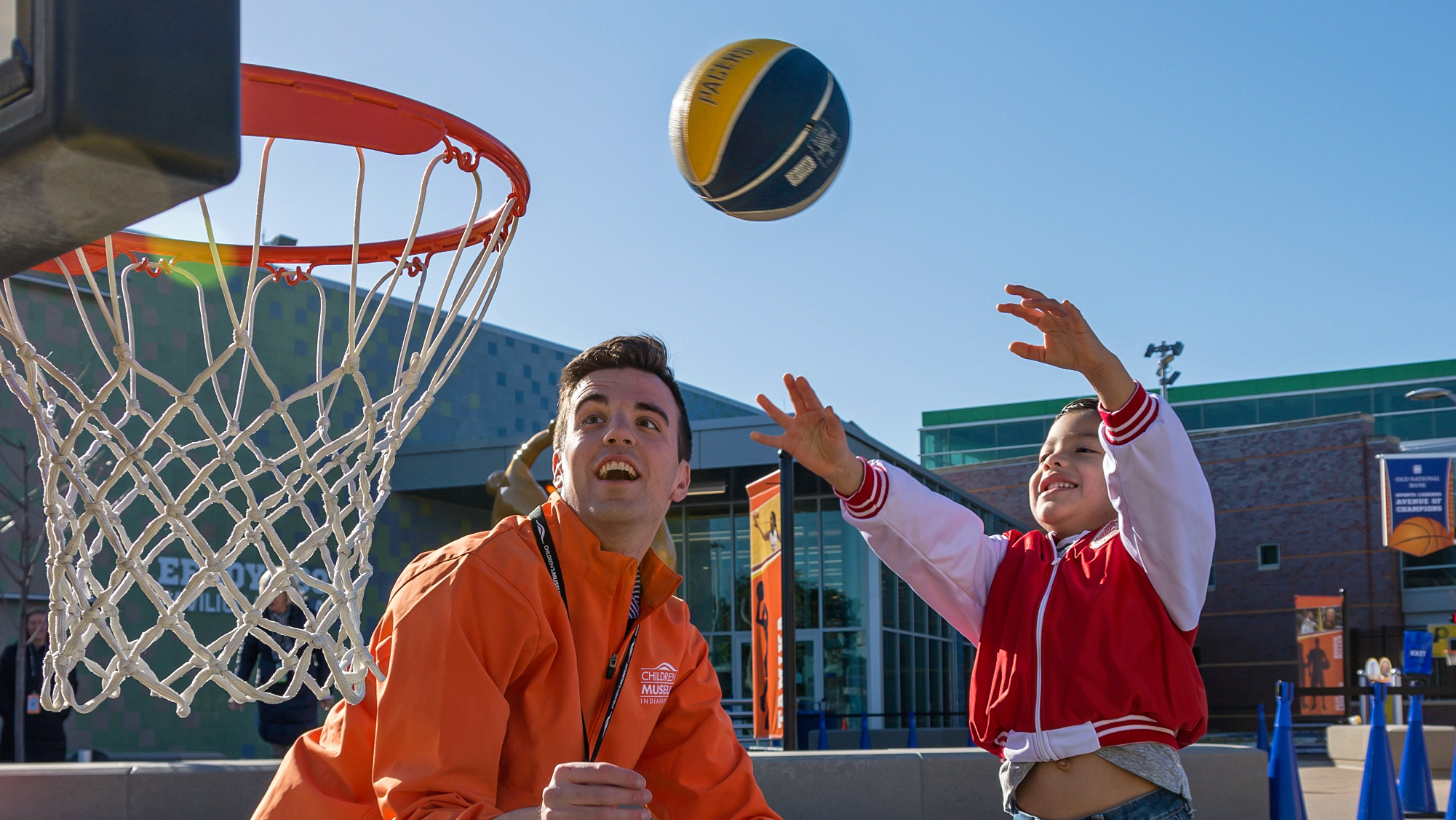 Coach watching child shoot a basketball.