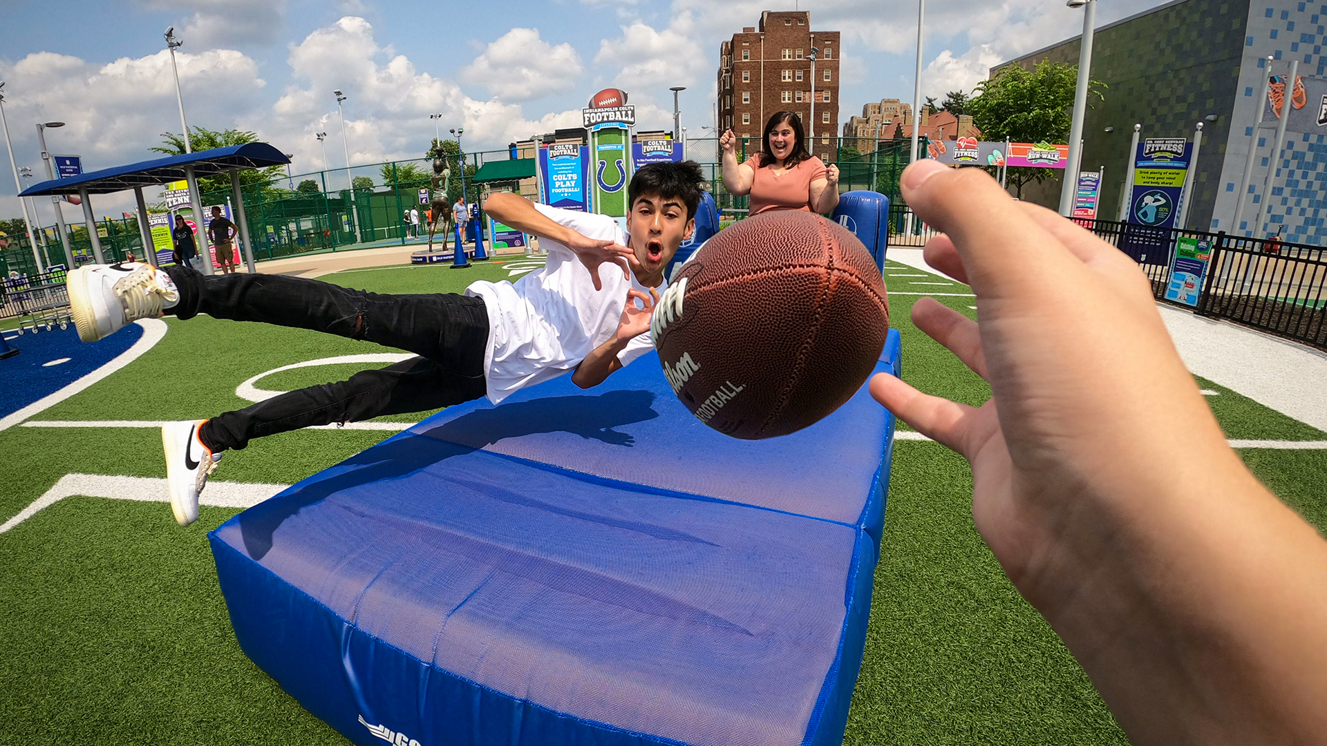 Child diving to catch a football.