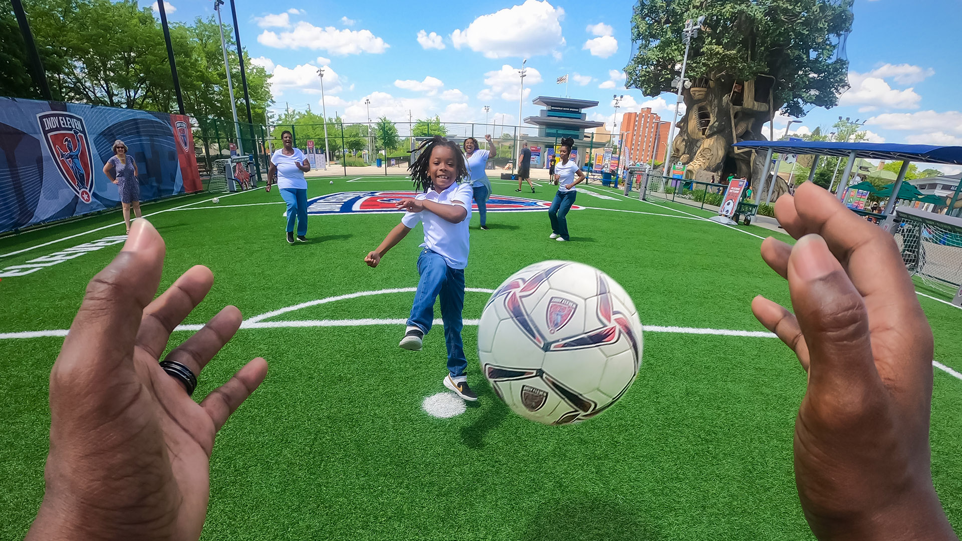 Goalkeeper hands reaching out to catch a soccer ball.