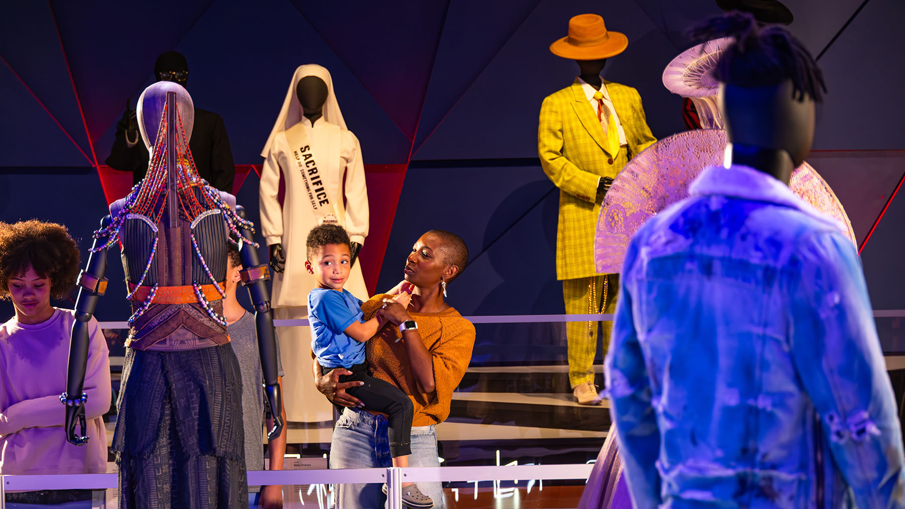 Mother and son look at costumes from Black Panther