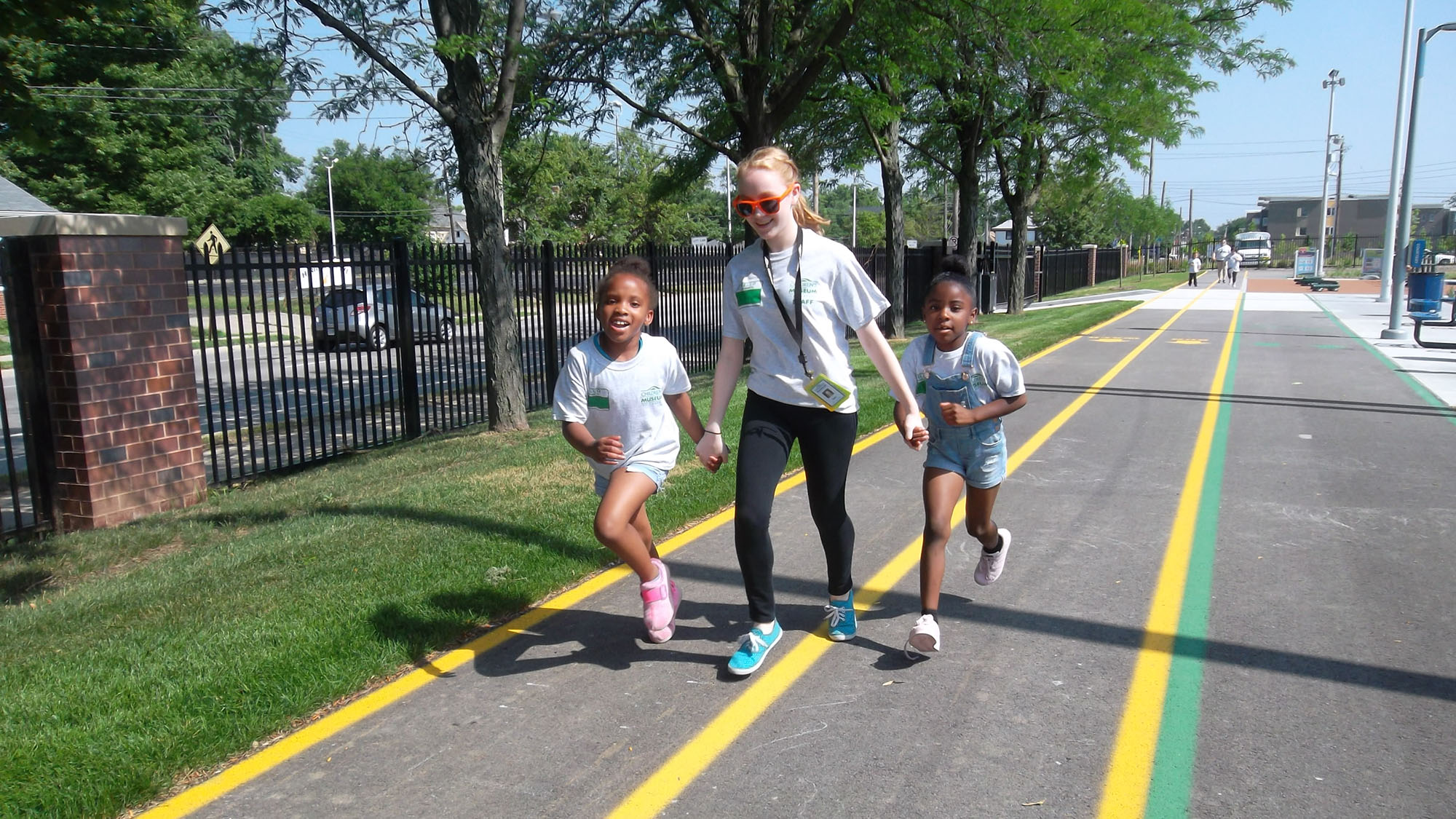 Children and staff member jogging on track.