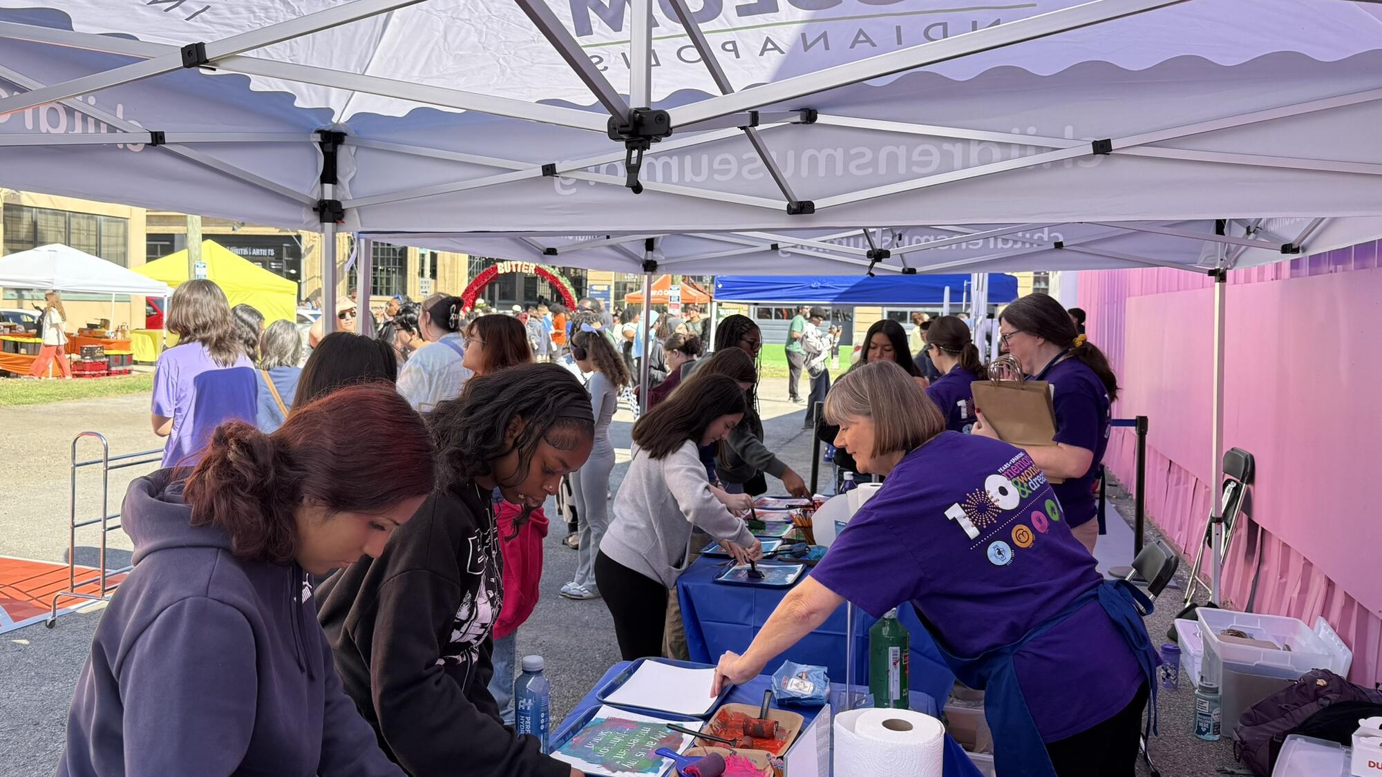 Museum staff helping visitors create art at BUTTER Fine Art Fair.