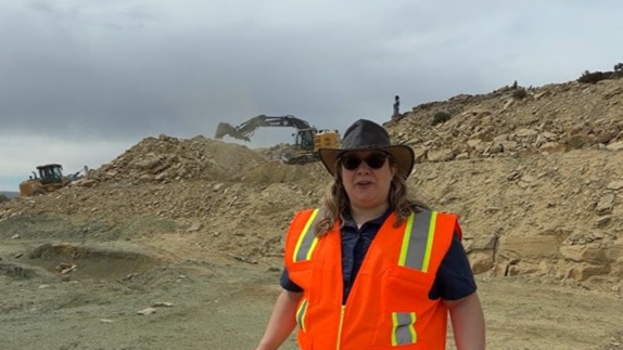 Screenshot from a video of Laura talking about the excavators behind her.
