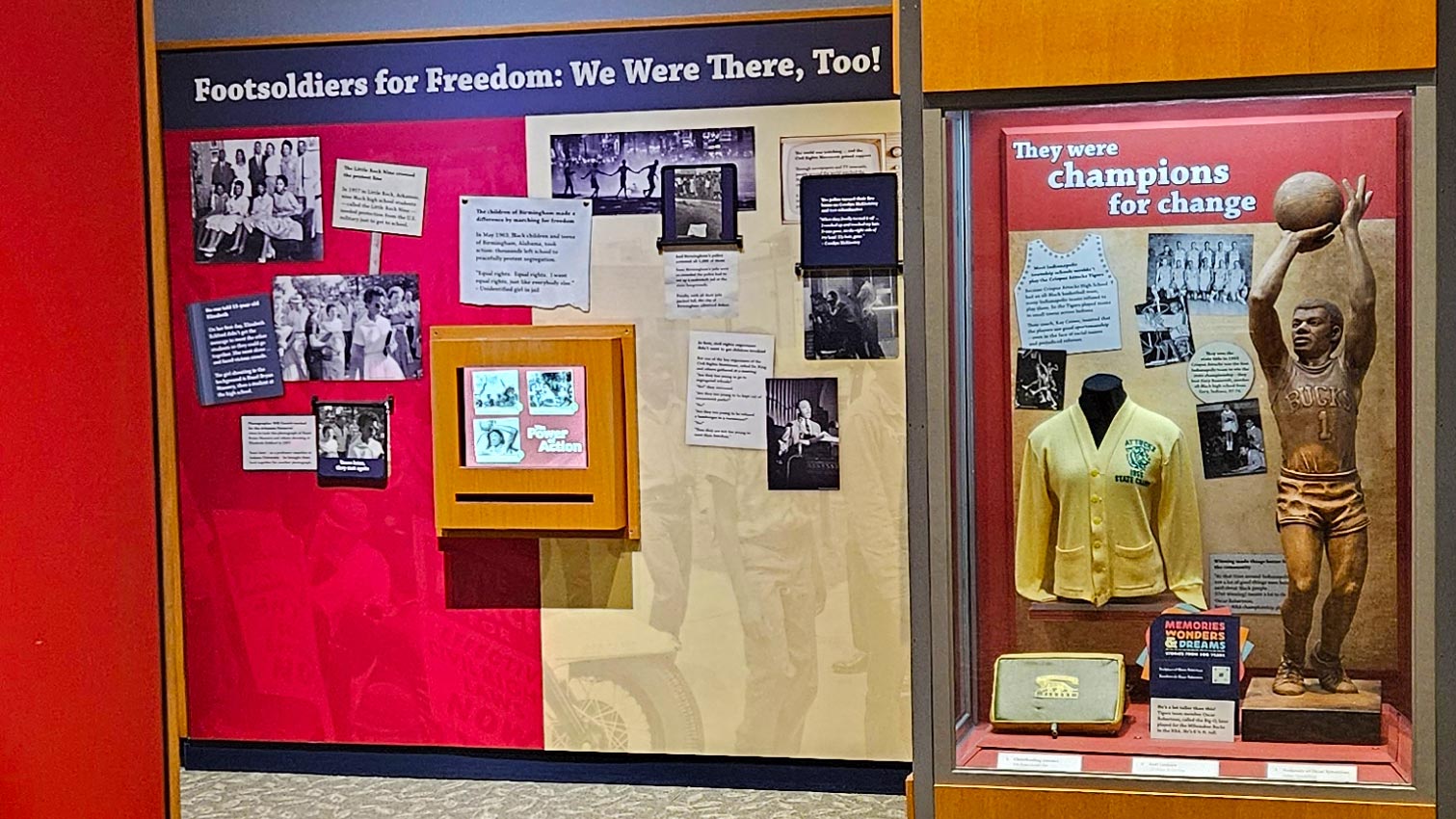 "Footsoldiers for Freedom: We Were There, Too!" and "They were champions for change" displays, including Crispus Attucks letter sweater and Oscar Robertson sculpture.