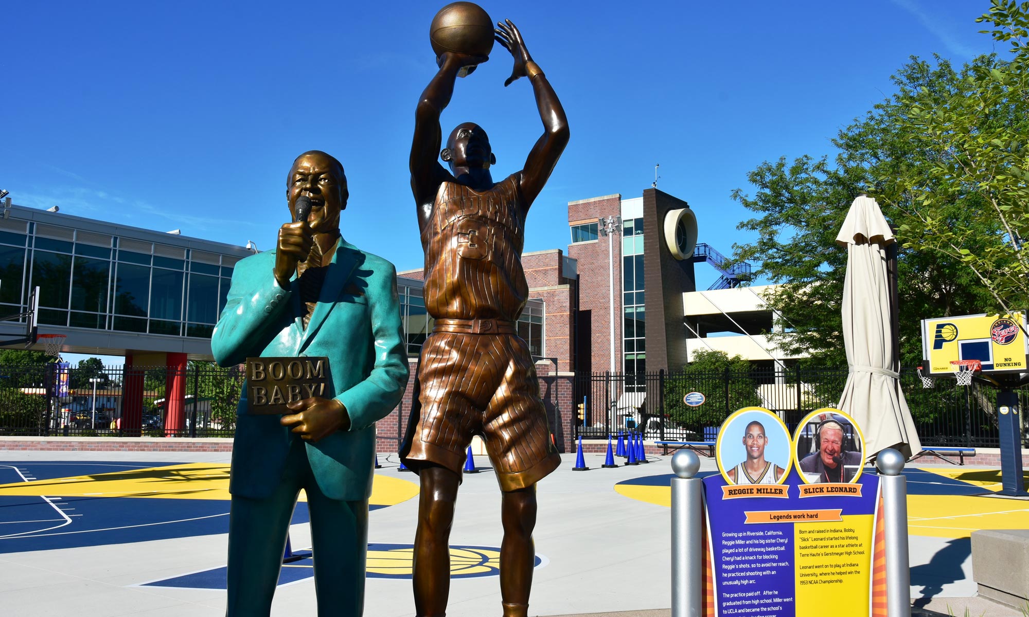 Statues of Reggie Miller shooting a basketball and Bobby "Slick" Leonard talking into a microphone.