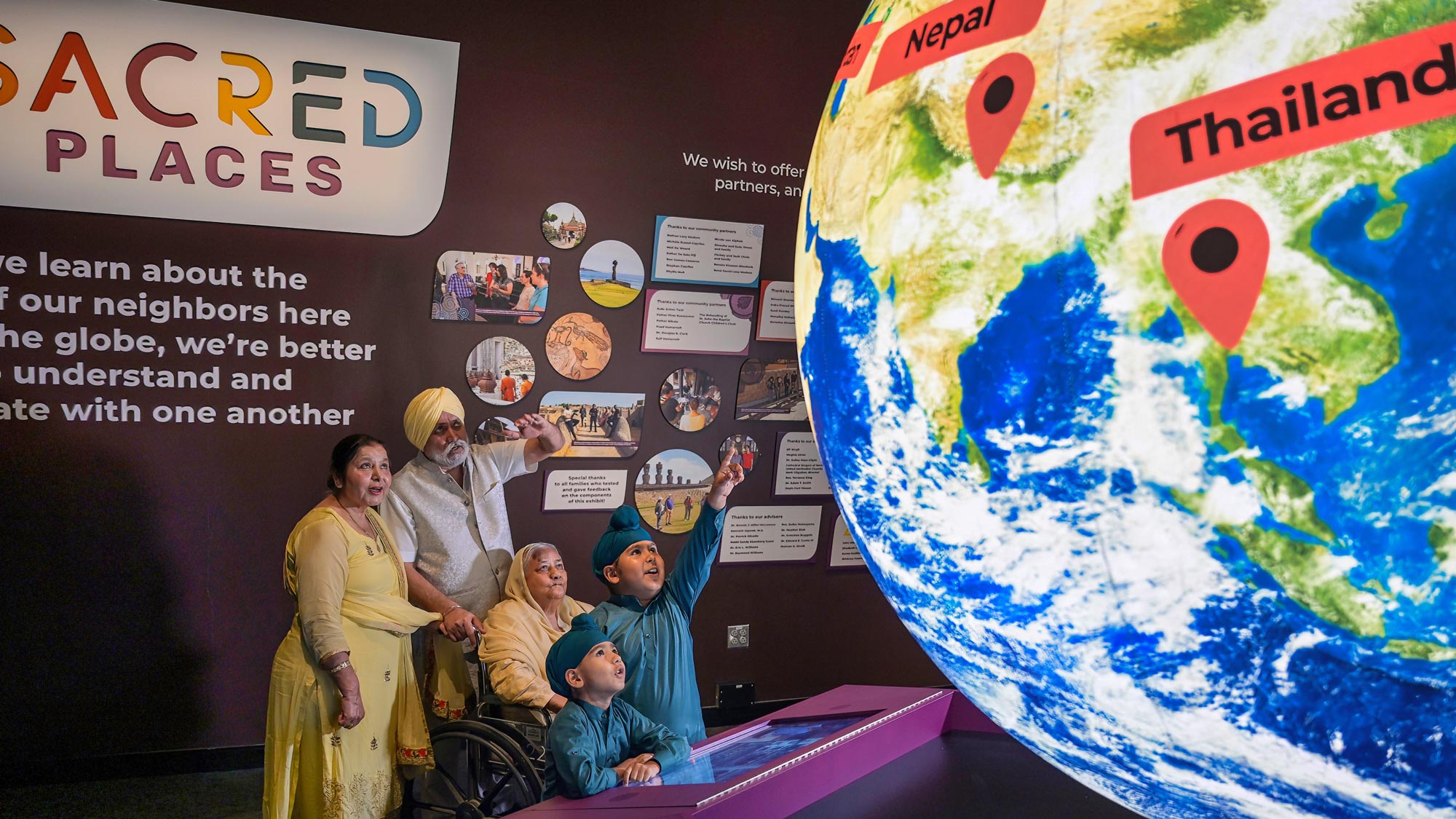 Family looking at a giant glowing model of the Earth.