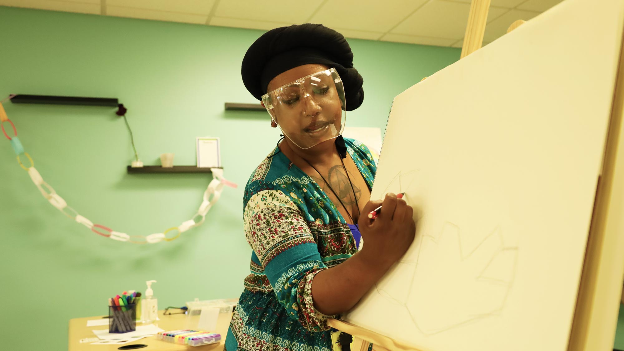Visiting Artist Deonna Craig drawing on canvas.