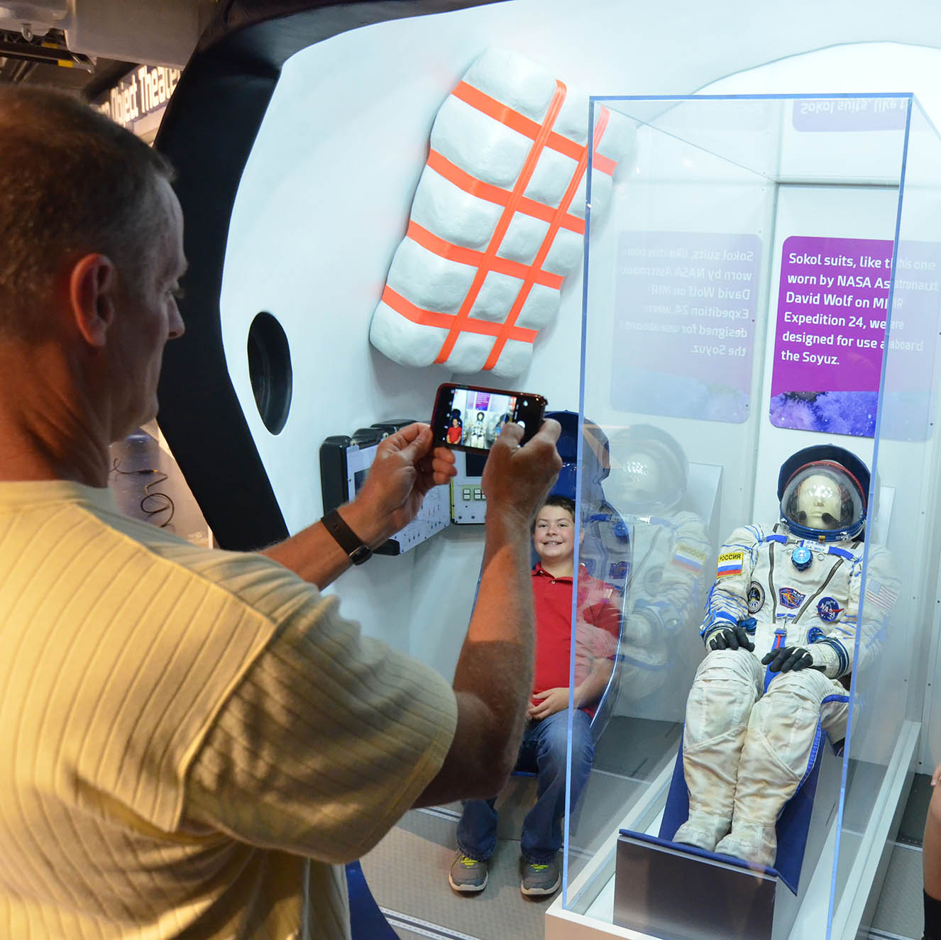 Person taking photo of Soyuz space capsule model.