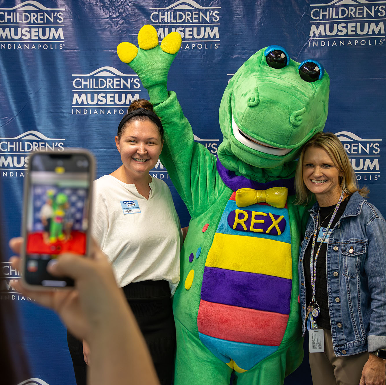 Mascot Rex posing with two educators.