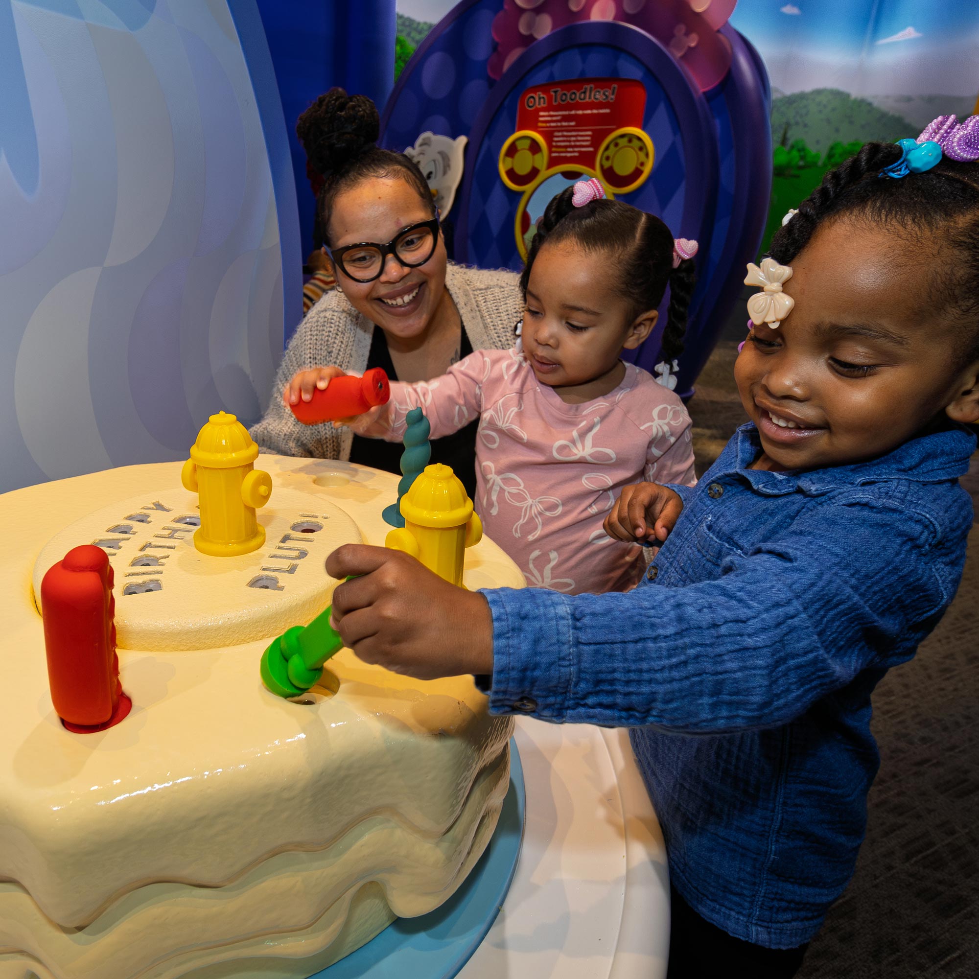 Children decorating a pretend-play birthday cake.