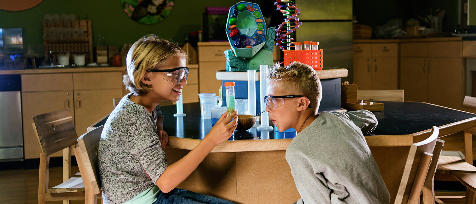 Two kids in a chemistry lab looking at beakers