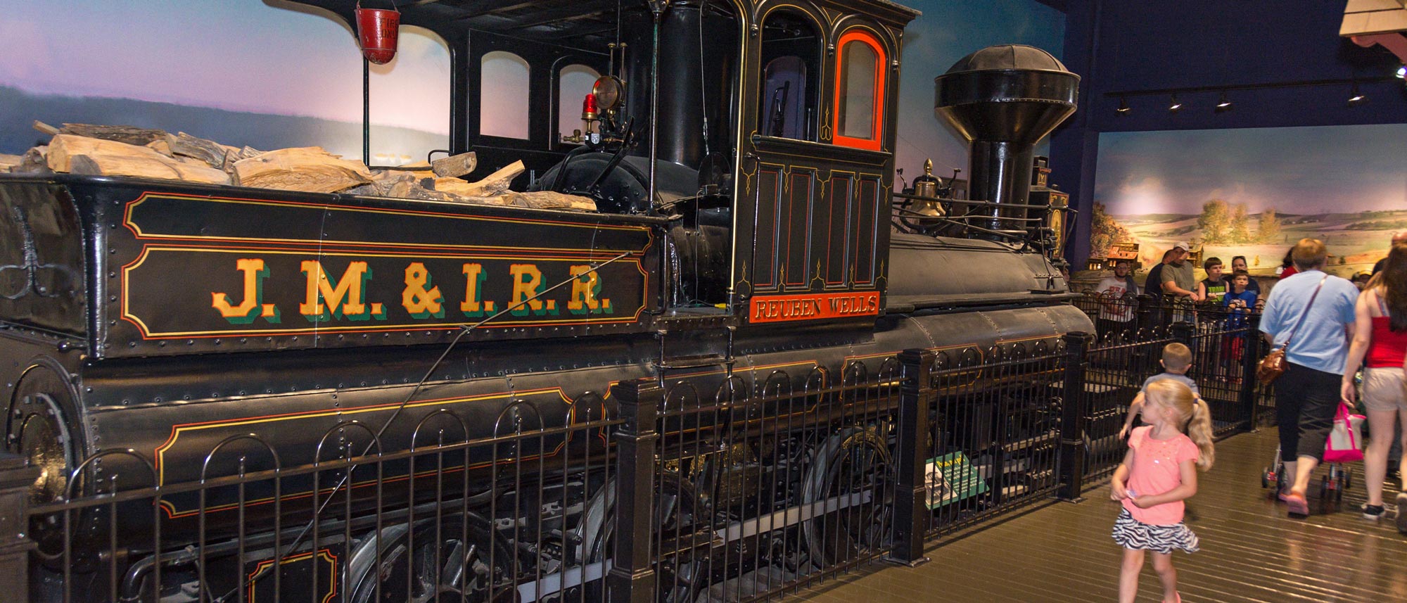 Families looking at the Reuben Wells train inside the exhibit.