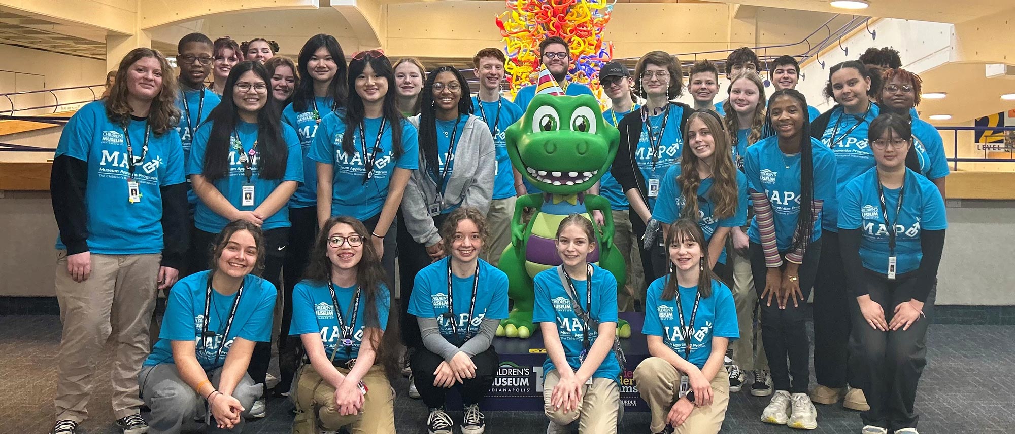 MAP participants posing with sculpture of museum mascot, Rex.