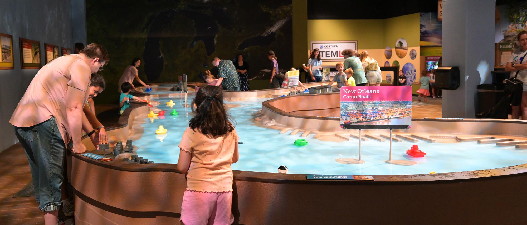 Children playing in with boats in a large water table.