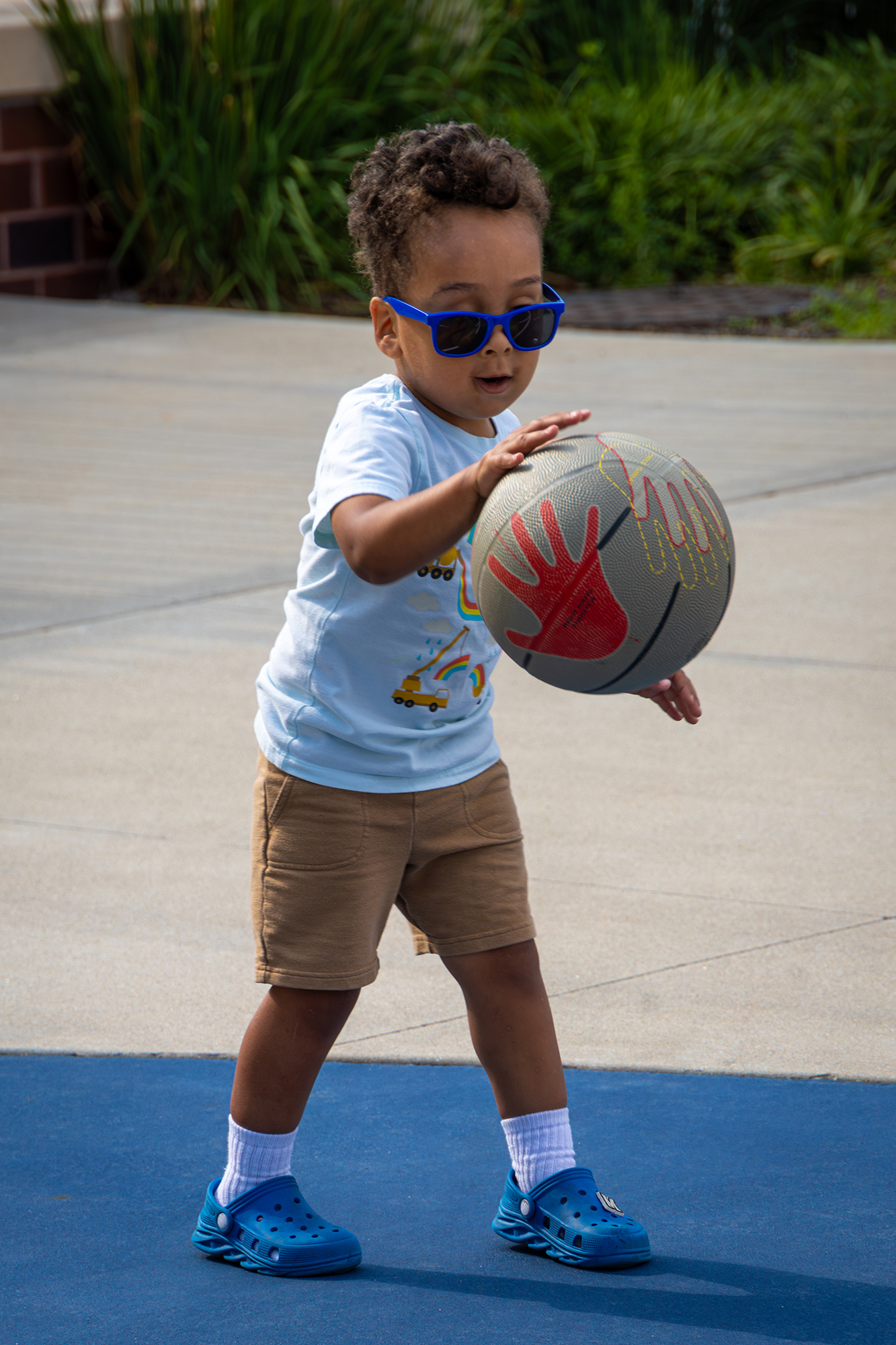 Child dribbling basketball.