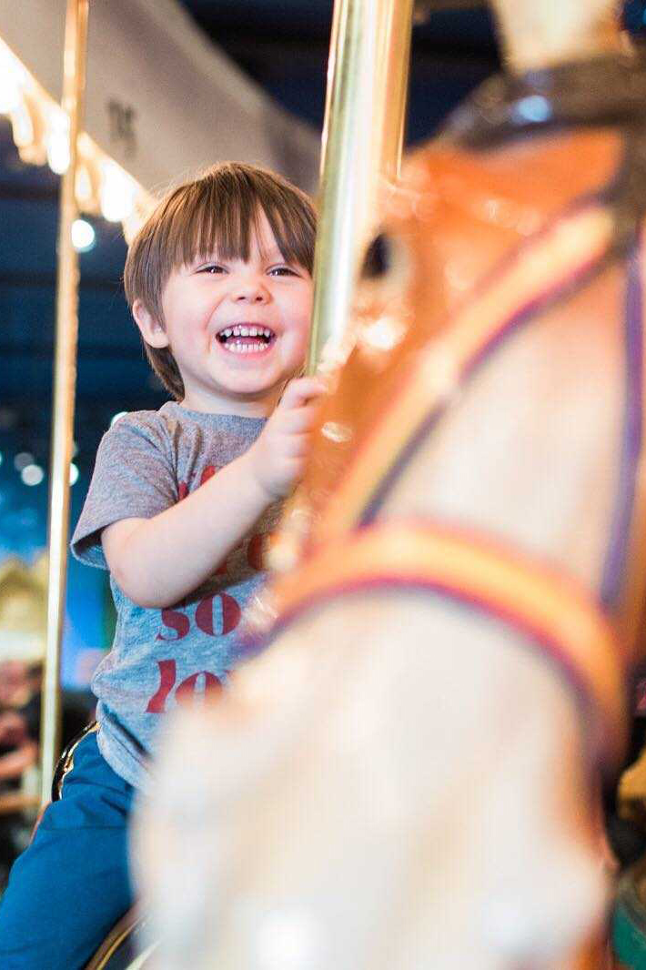 Smiling child on Carousel horse.