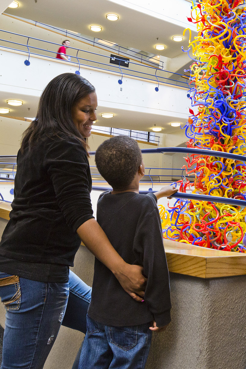 Grown-up and child looking at Fireworks of Glass sculpture.