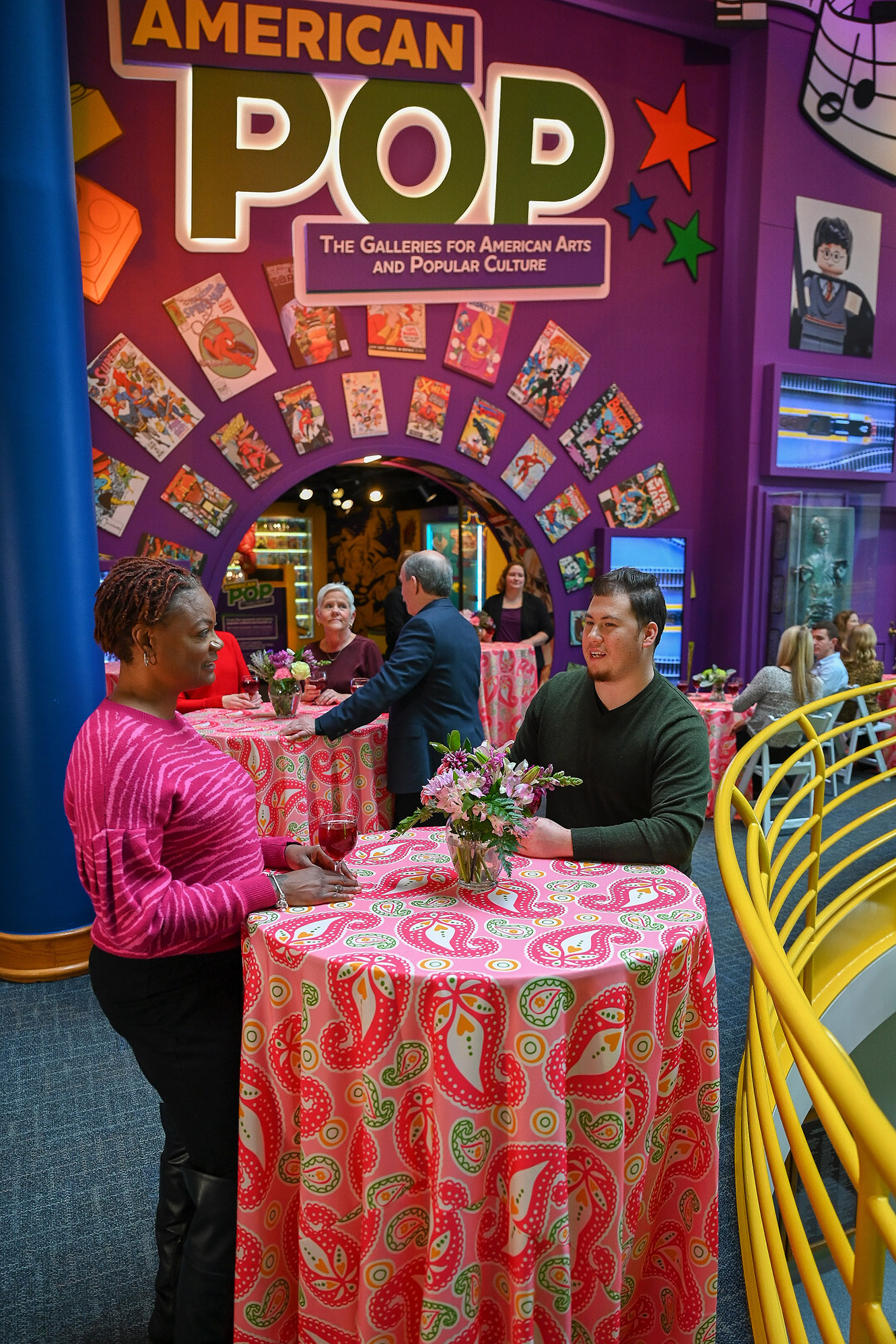 People sitting at tables outside American POP exhibit.