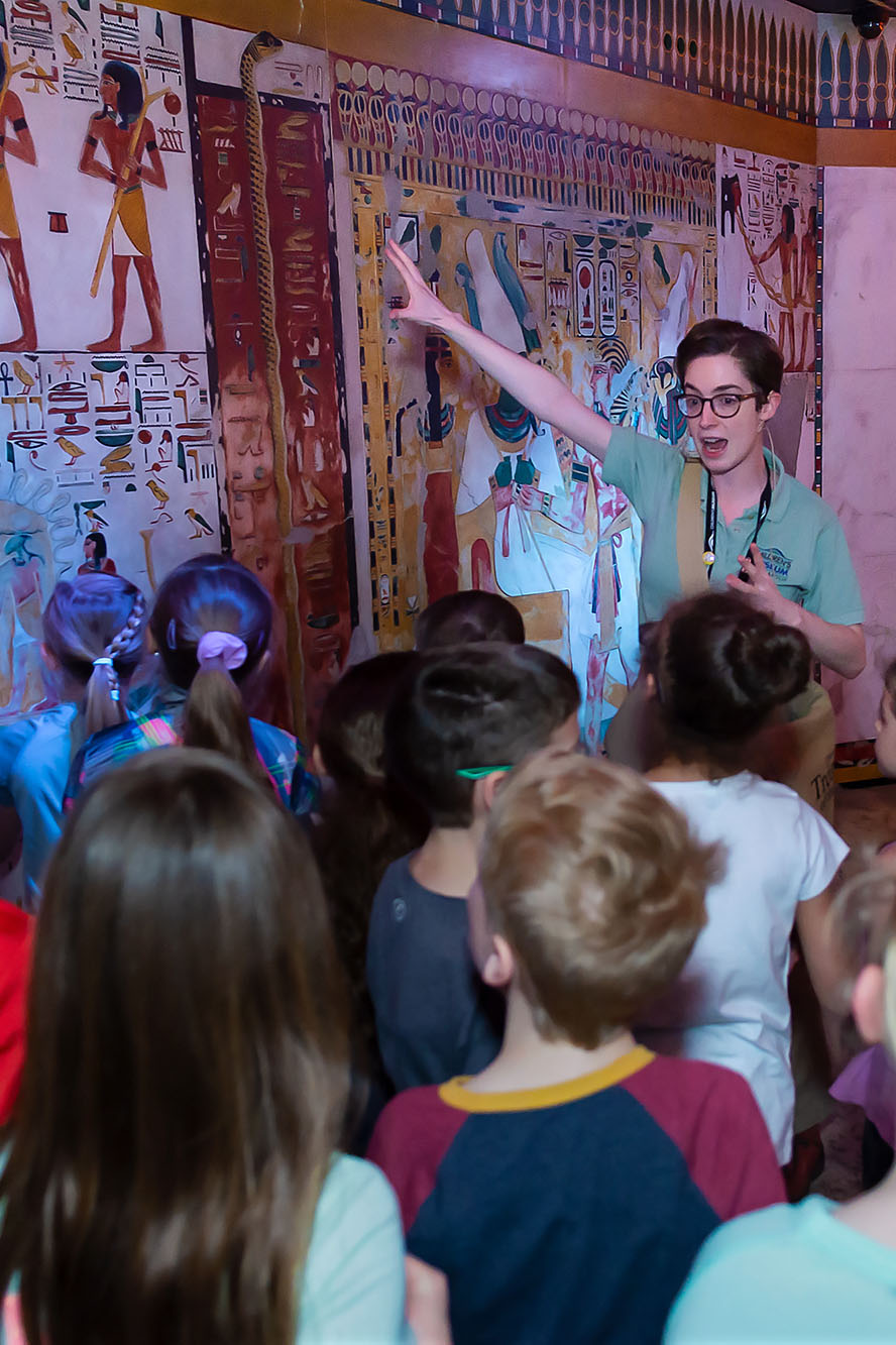 Staff member pointing to a wall of hieroglyphics. 