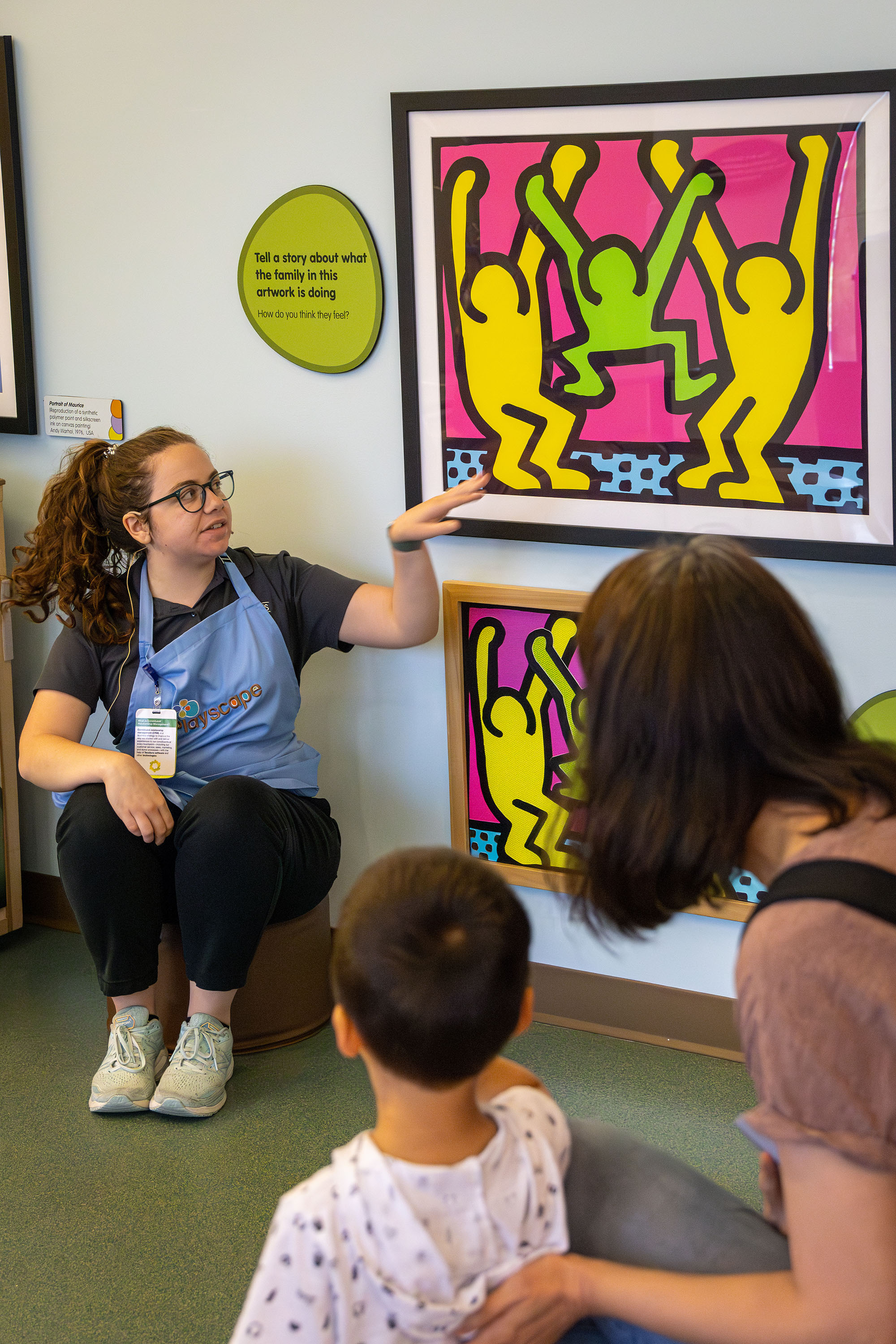 Staff member and children looking at a painting.