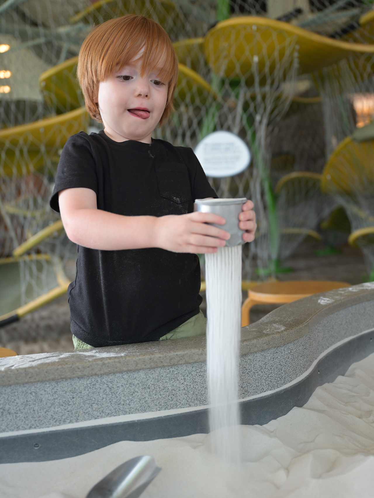 Child sifting sand.