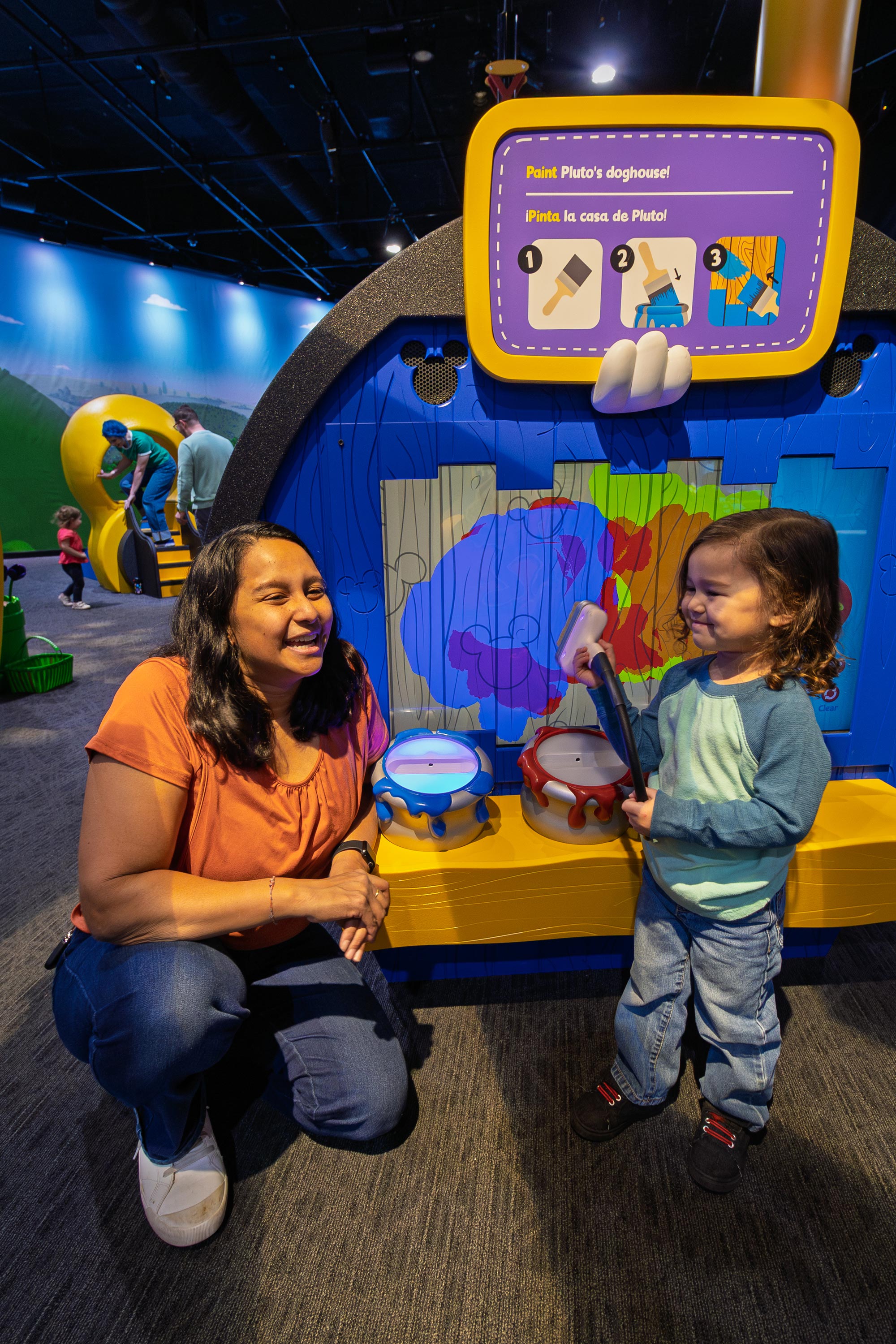 Grown-up and child playing in exhibit.