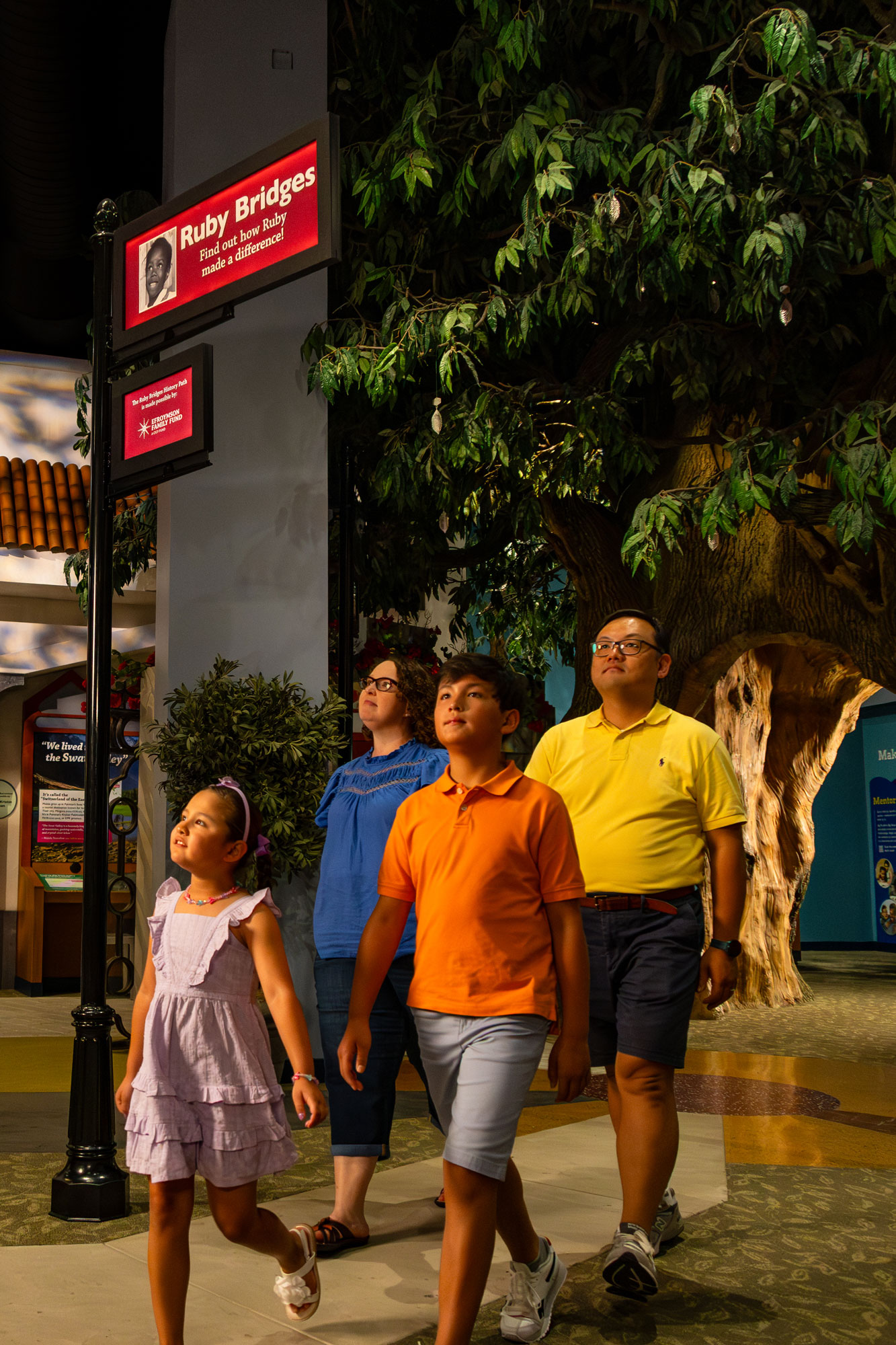 Family walking under Ruby Bridges sign in the Power of Children exhibit.