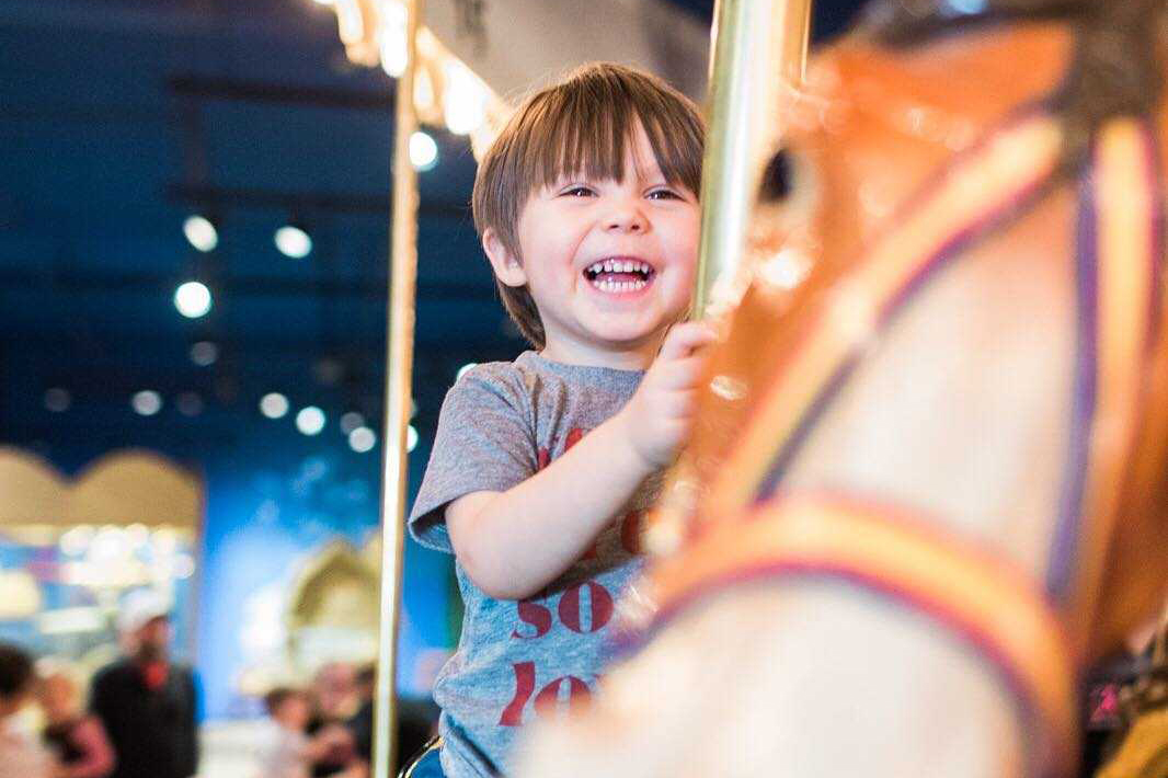 Child riding Carousel horse.