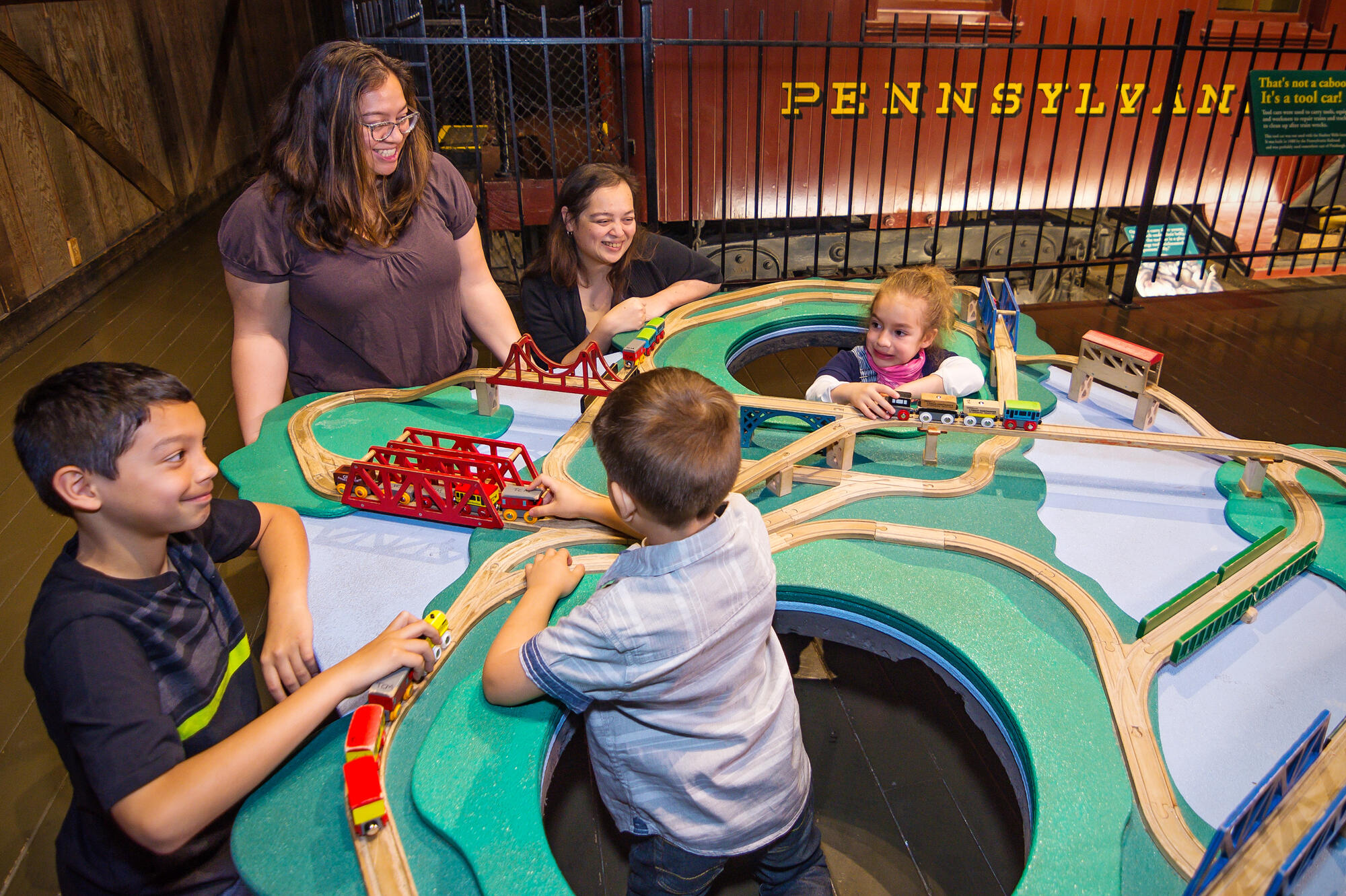 Children playing at train play table.
