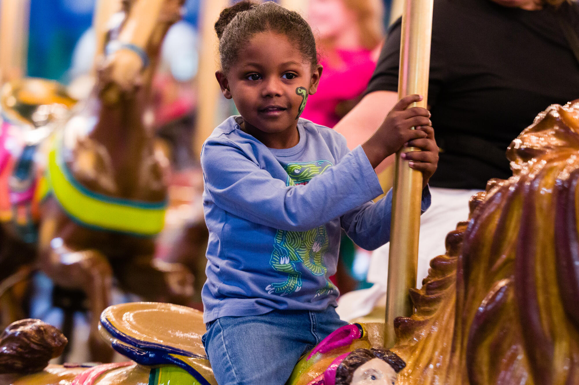 Child riding Carousel horse.