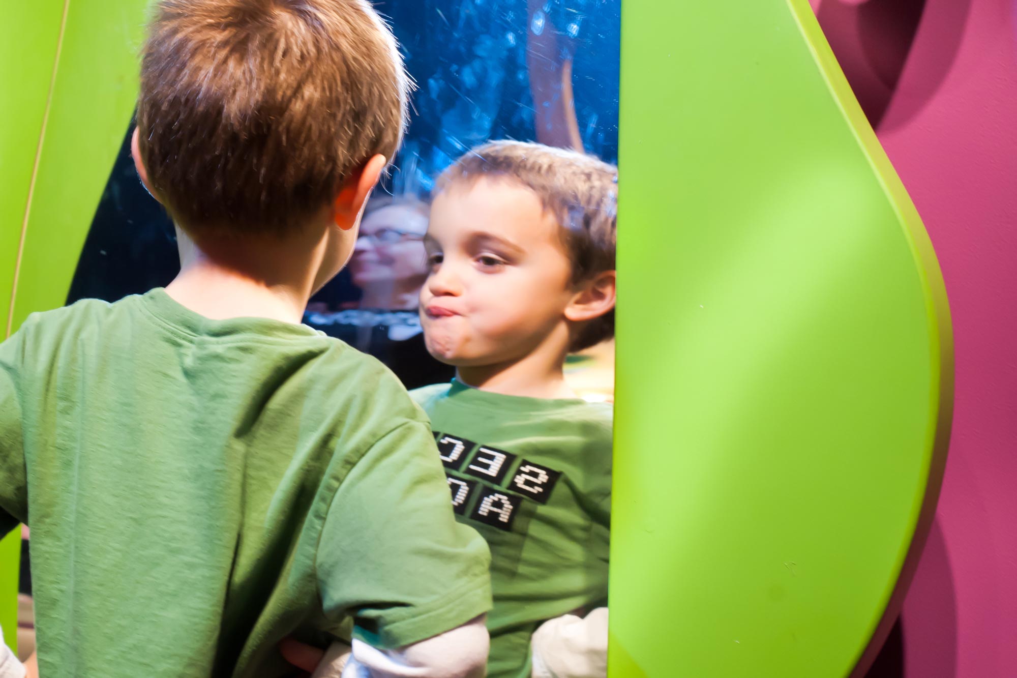 Child making faces in a mirror.