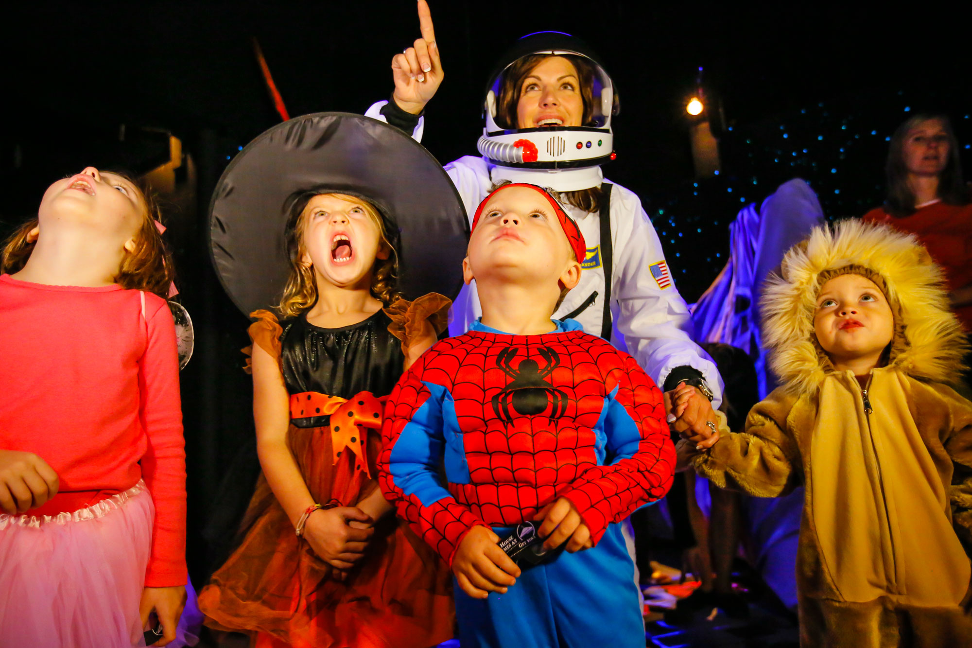 Children wearing Halloween costumes and looking up.
