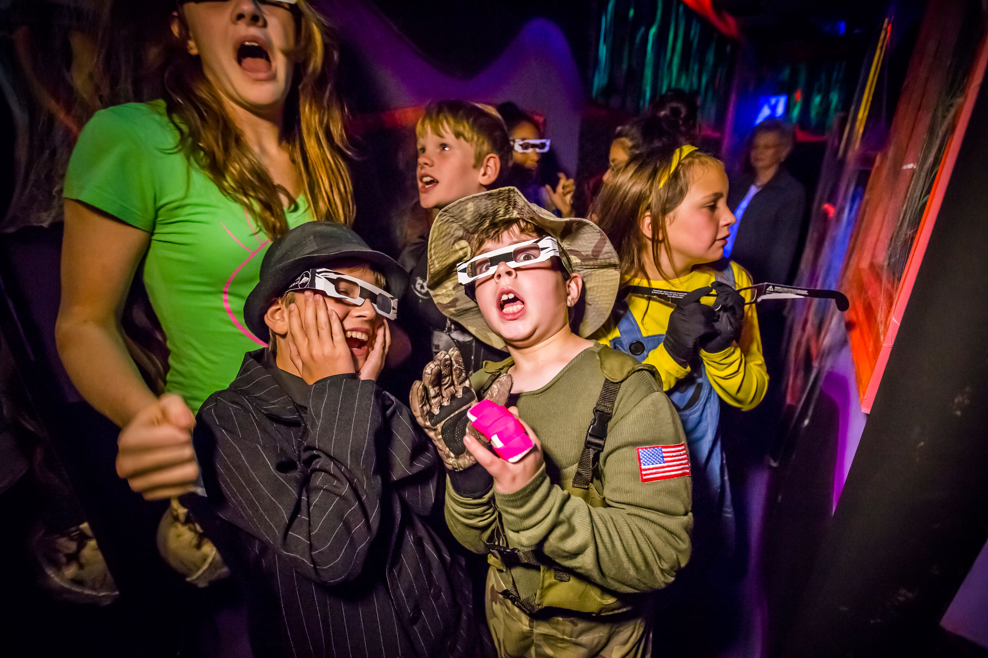 Family wearing costumes and screaming at something off screen. 