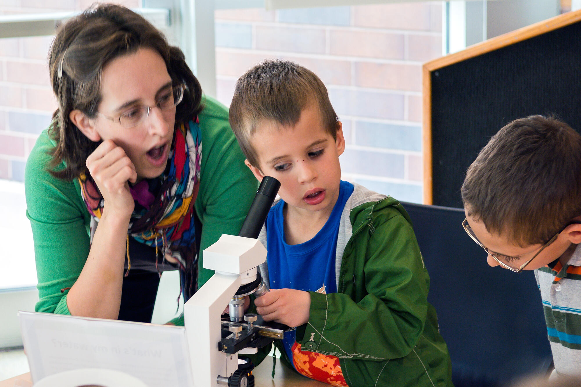 Child looking through microscope.