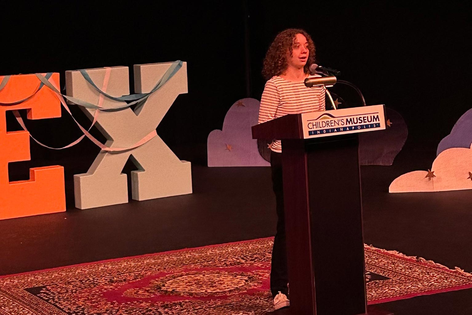 Emma standing behind a podium giving her presentation.