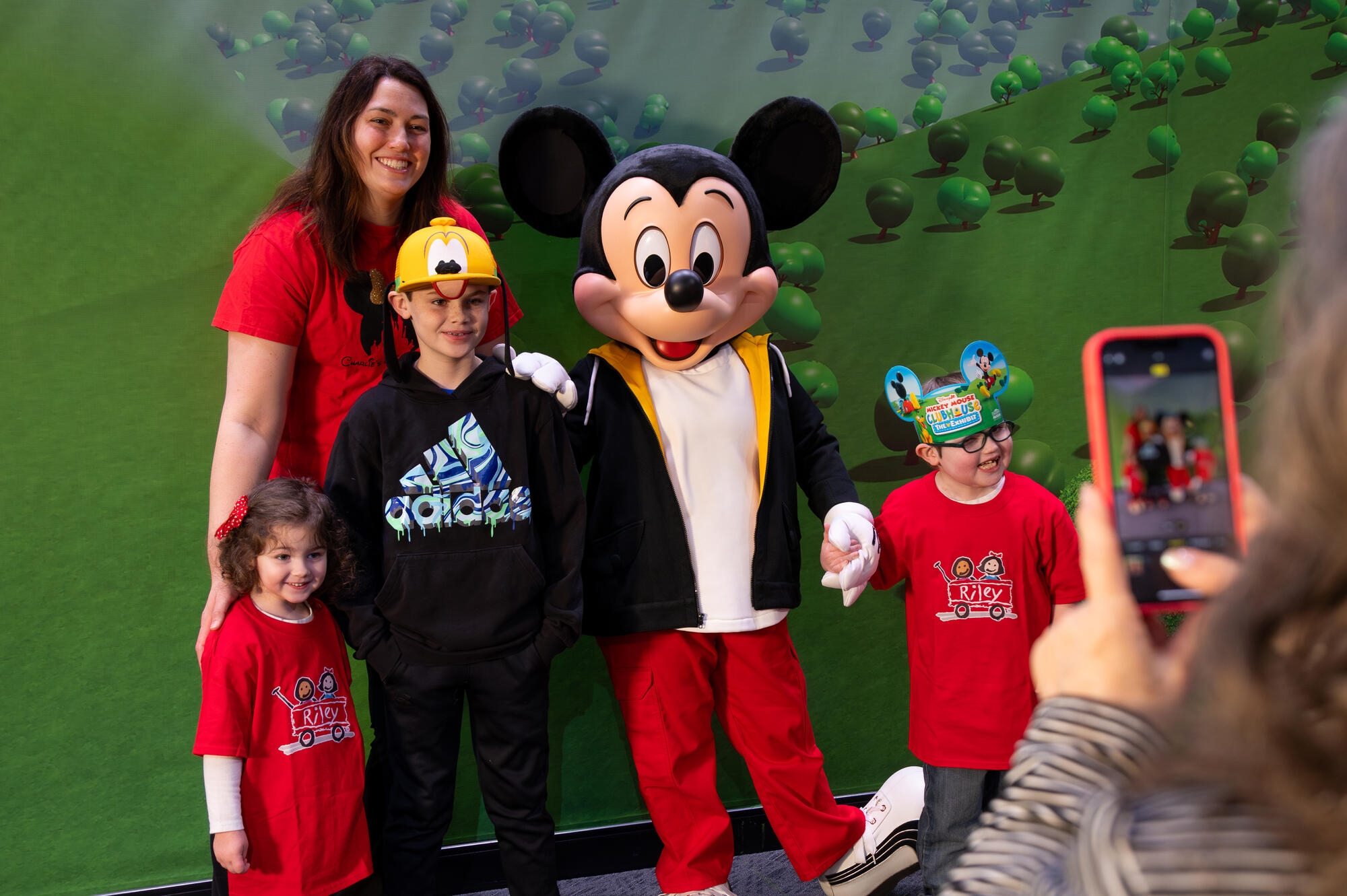 Mickey Mouse posing for a photo with a family from Riley Children's Health.