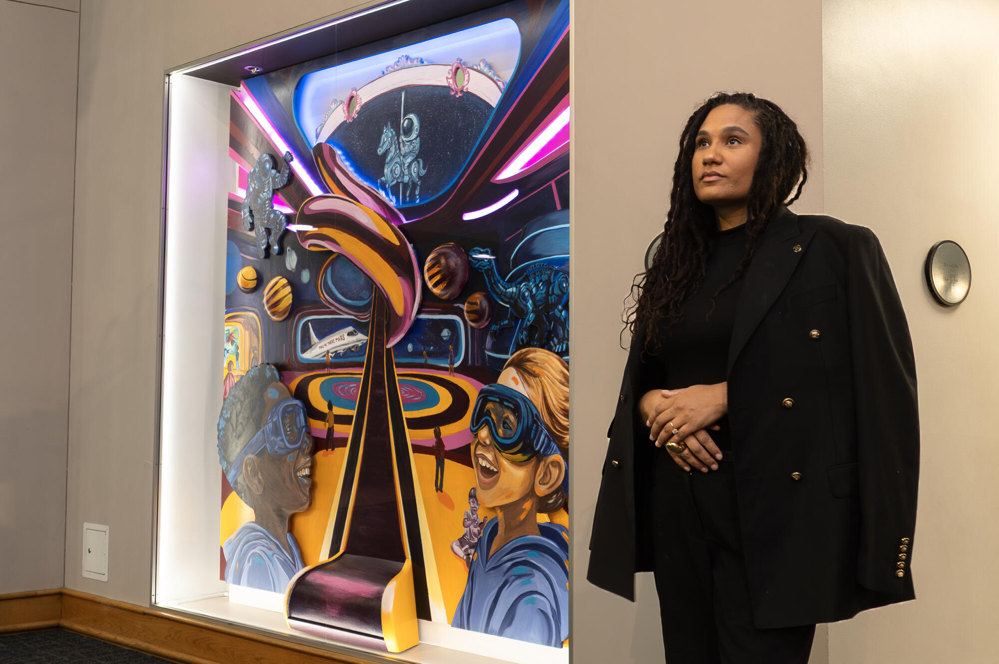 Artist Ashley Nora standing next to the bottom third of Memories, Wonders, and Dreams artwork.