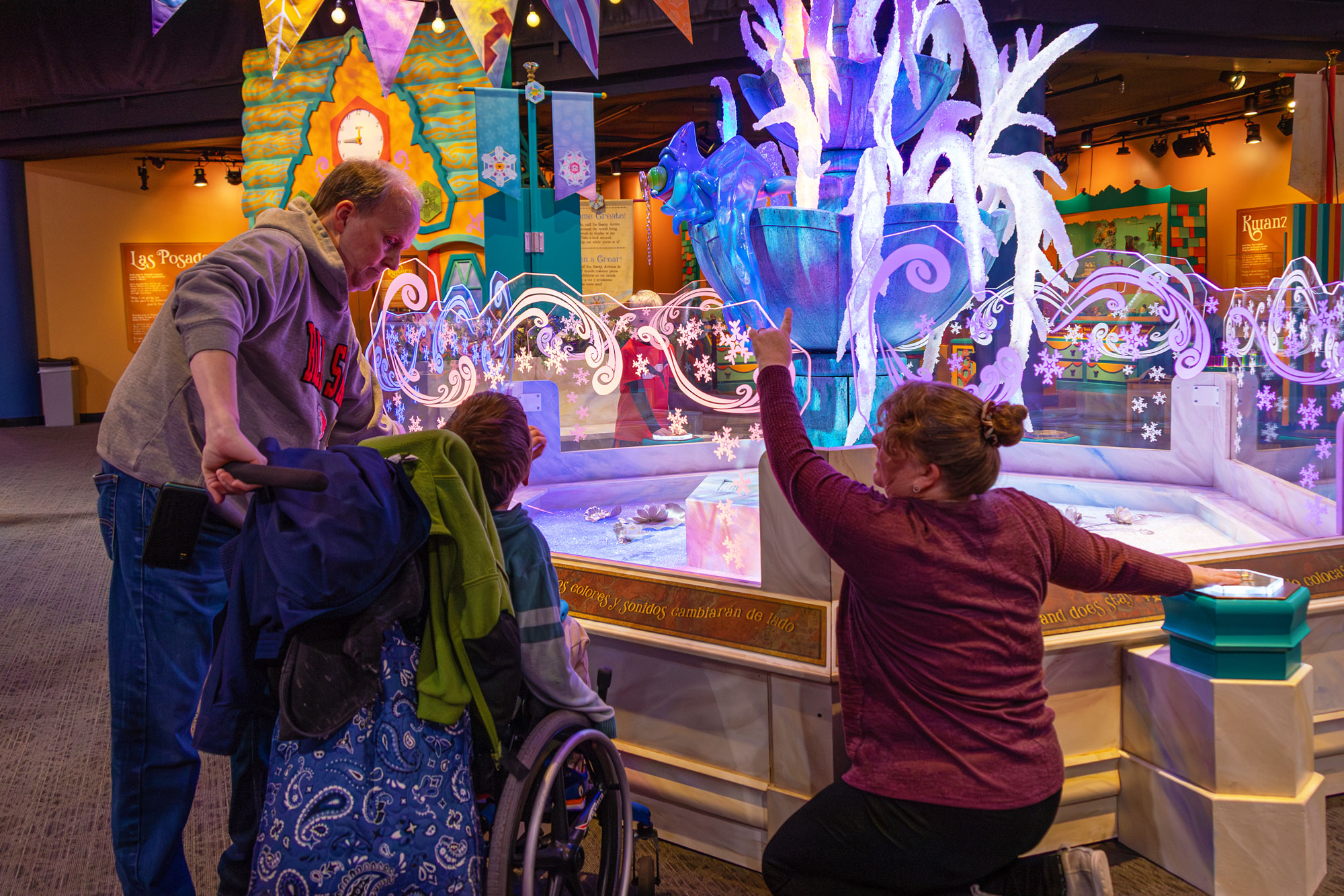 Family operating the magic fountain inside the WinterFaire exhibit.