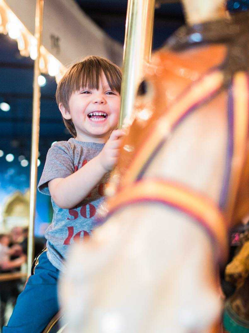 Child riding Carousel horse.