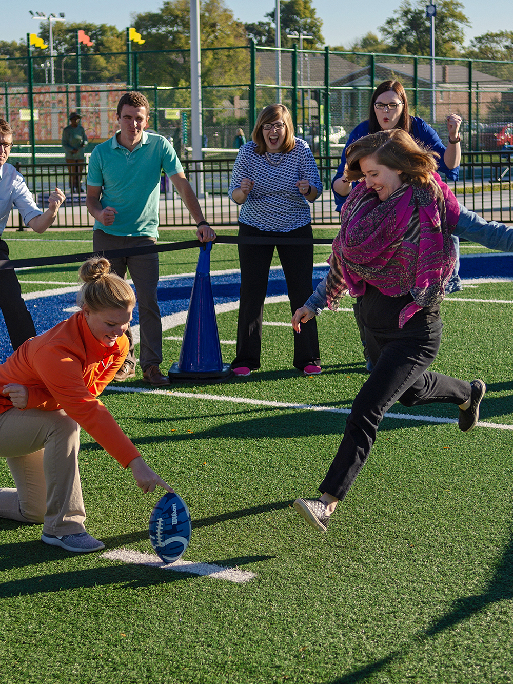 Grown-up kicking a football.