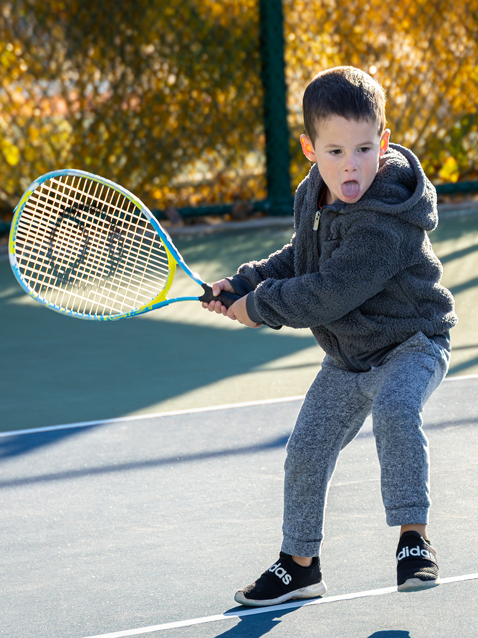 Child swinging a tennis racquet.