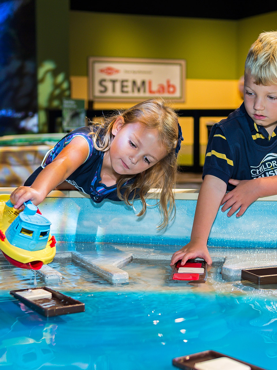 Children playing with toy boats.