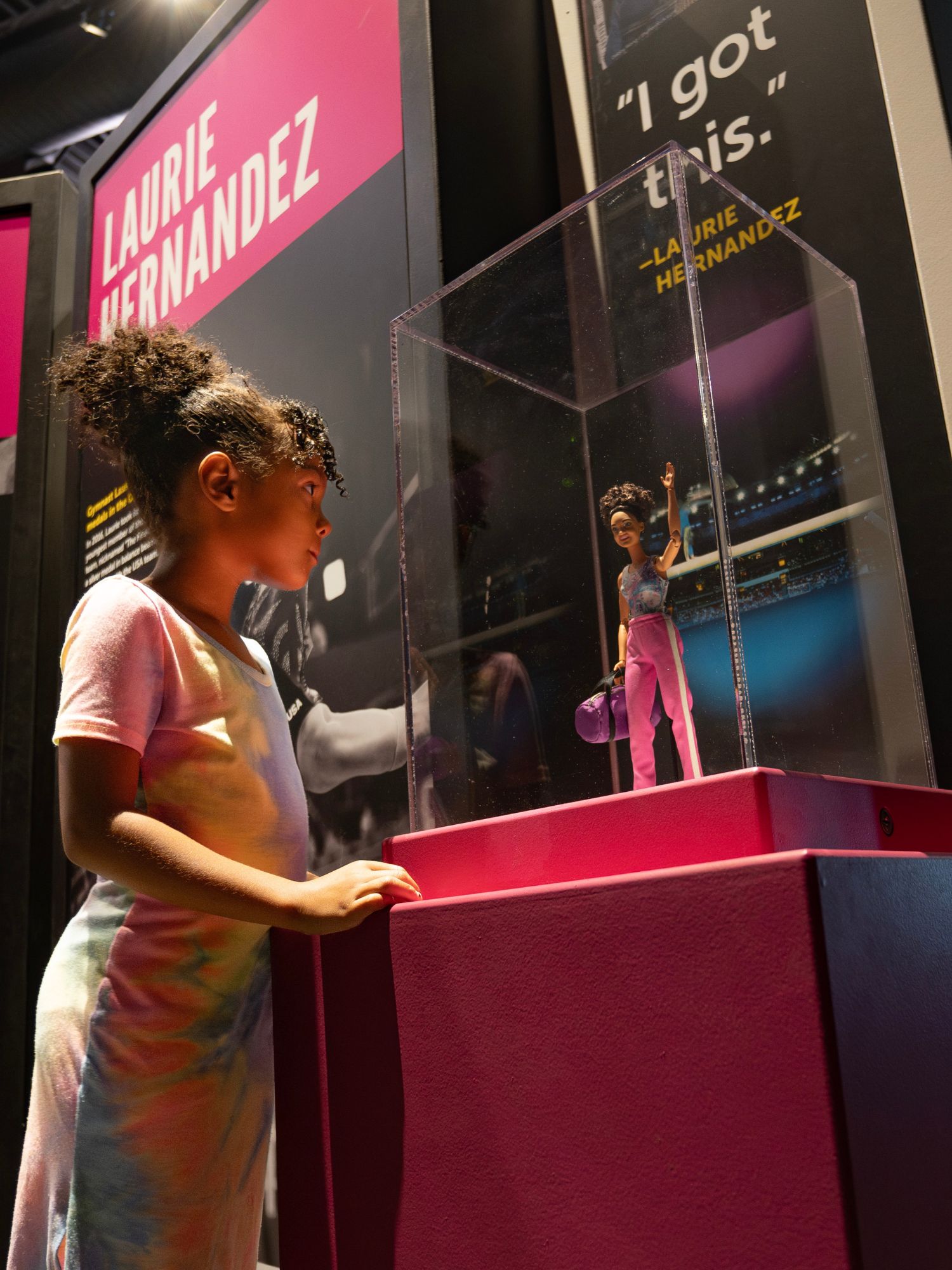 Child looking at Laurie Hernandez Barbie doll.