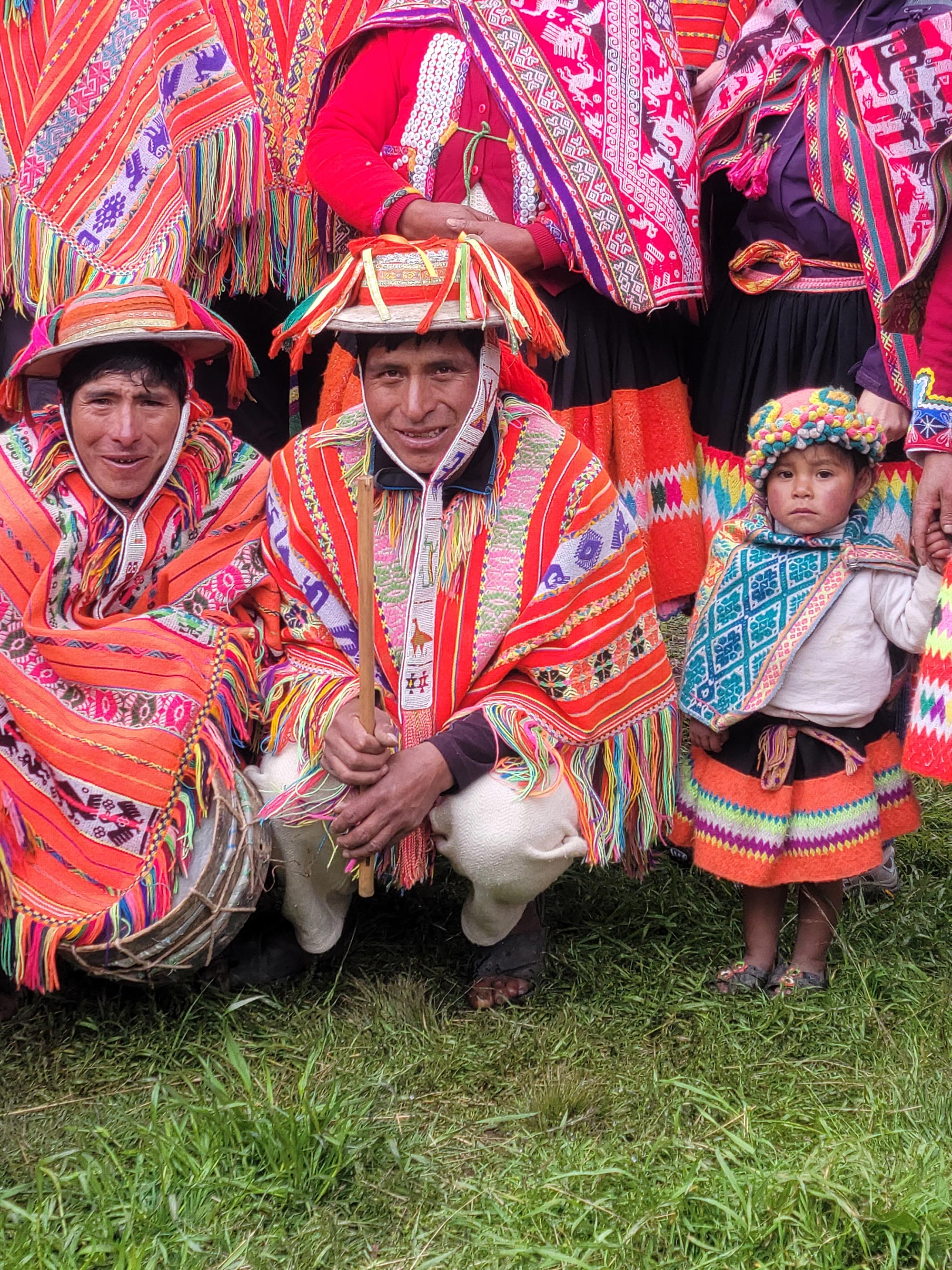 Peruvian family wearing brightly colored traditional clothing.