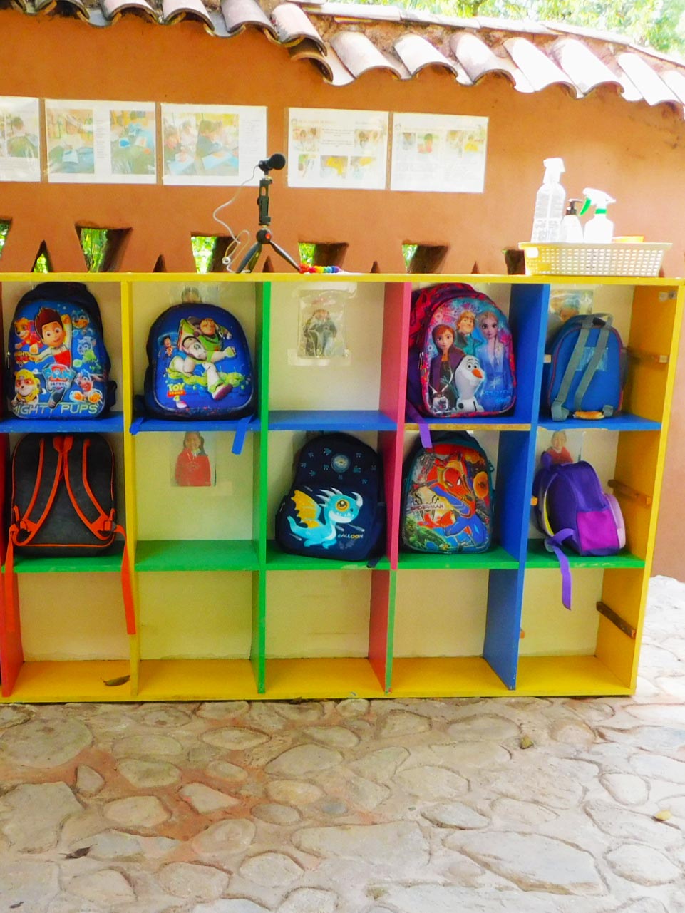 Backpacks hanging in cube storage shelves in a school in Peru.