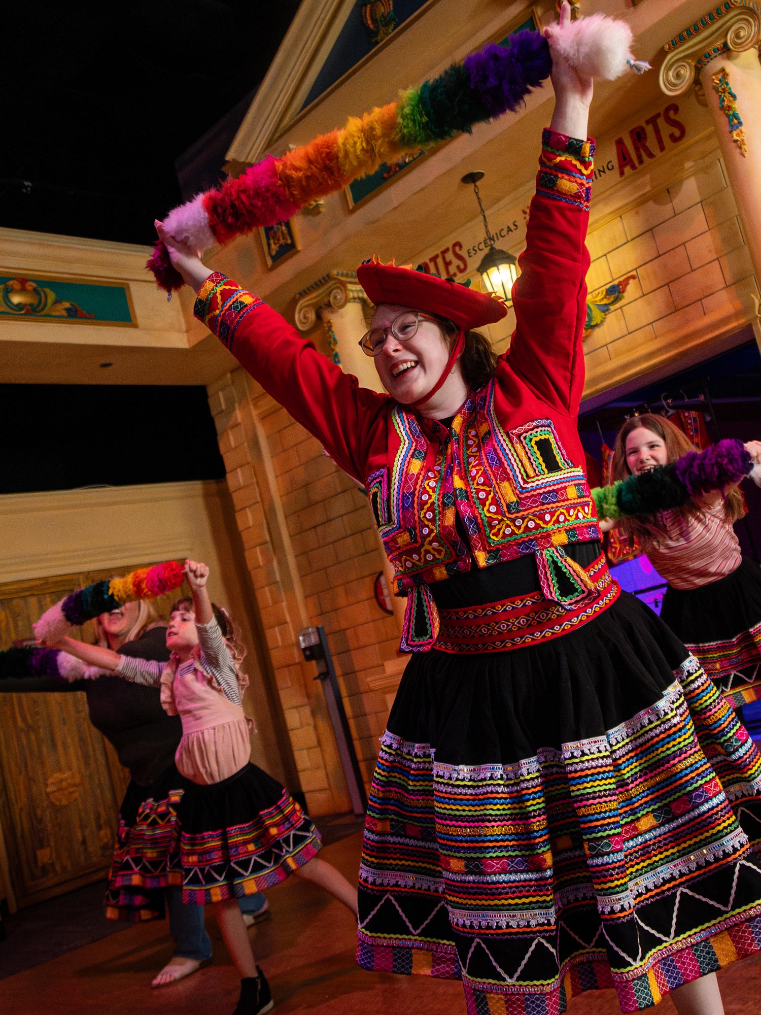 Staff member teaching children traditional Peruvian dance in Take Me There: Peru exhibit.