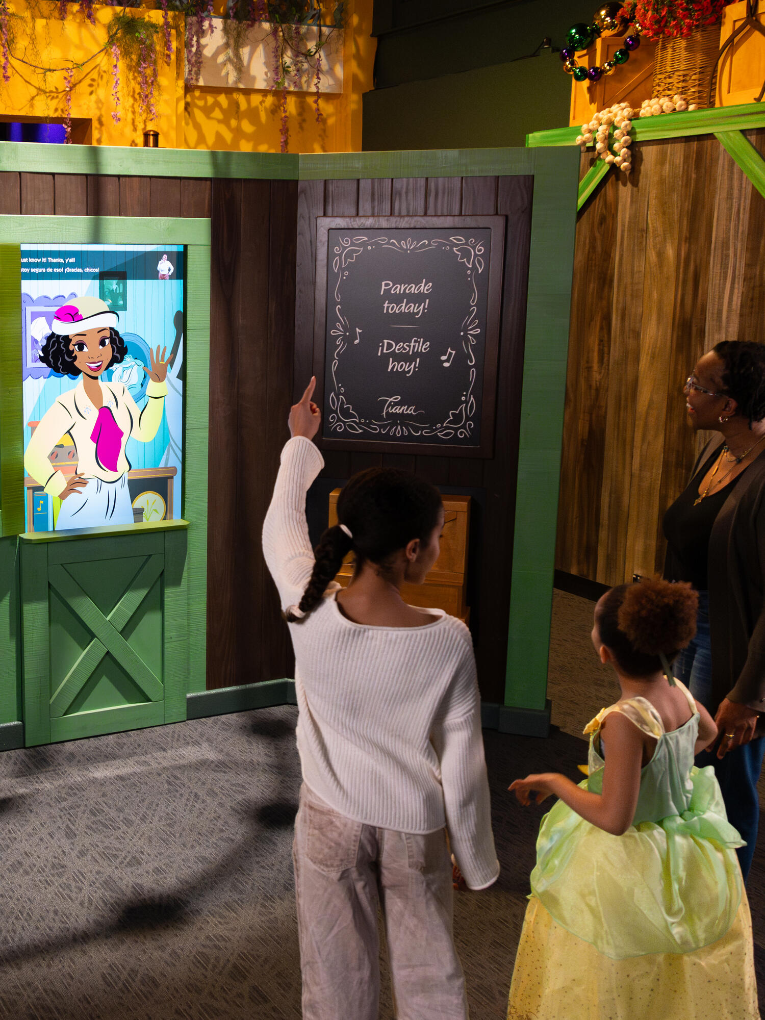 Family watching a screen with Tiana on it.