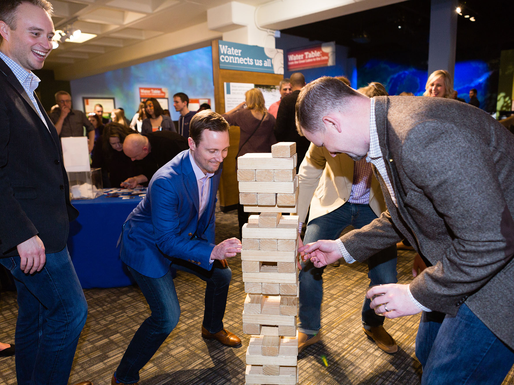 Grown-ups playing giant wooden puzzle. 