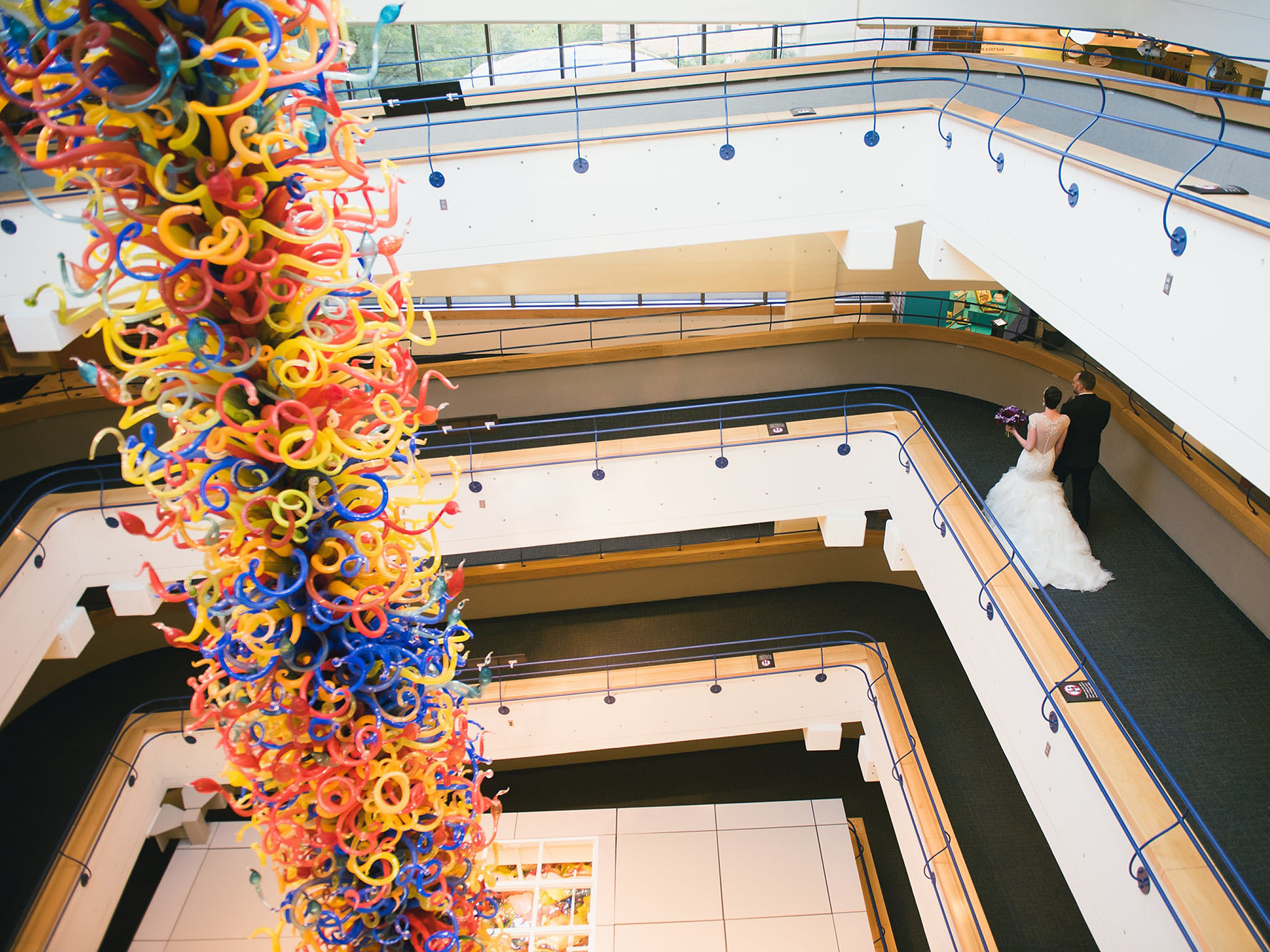 Bride and groom beside Chihuly Fireworks of Glass sculpture.