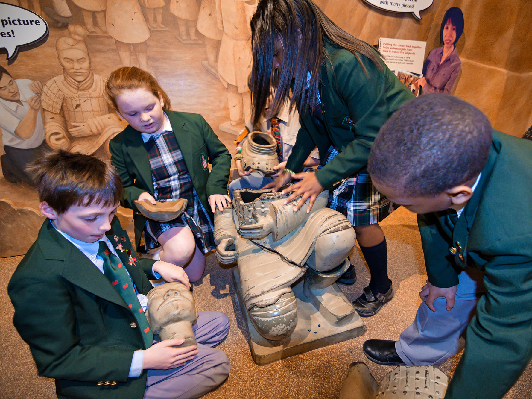 Children piecing together a statue of a Terra Cotta Warrior. 